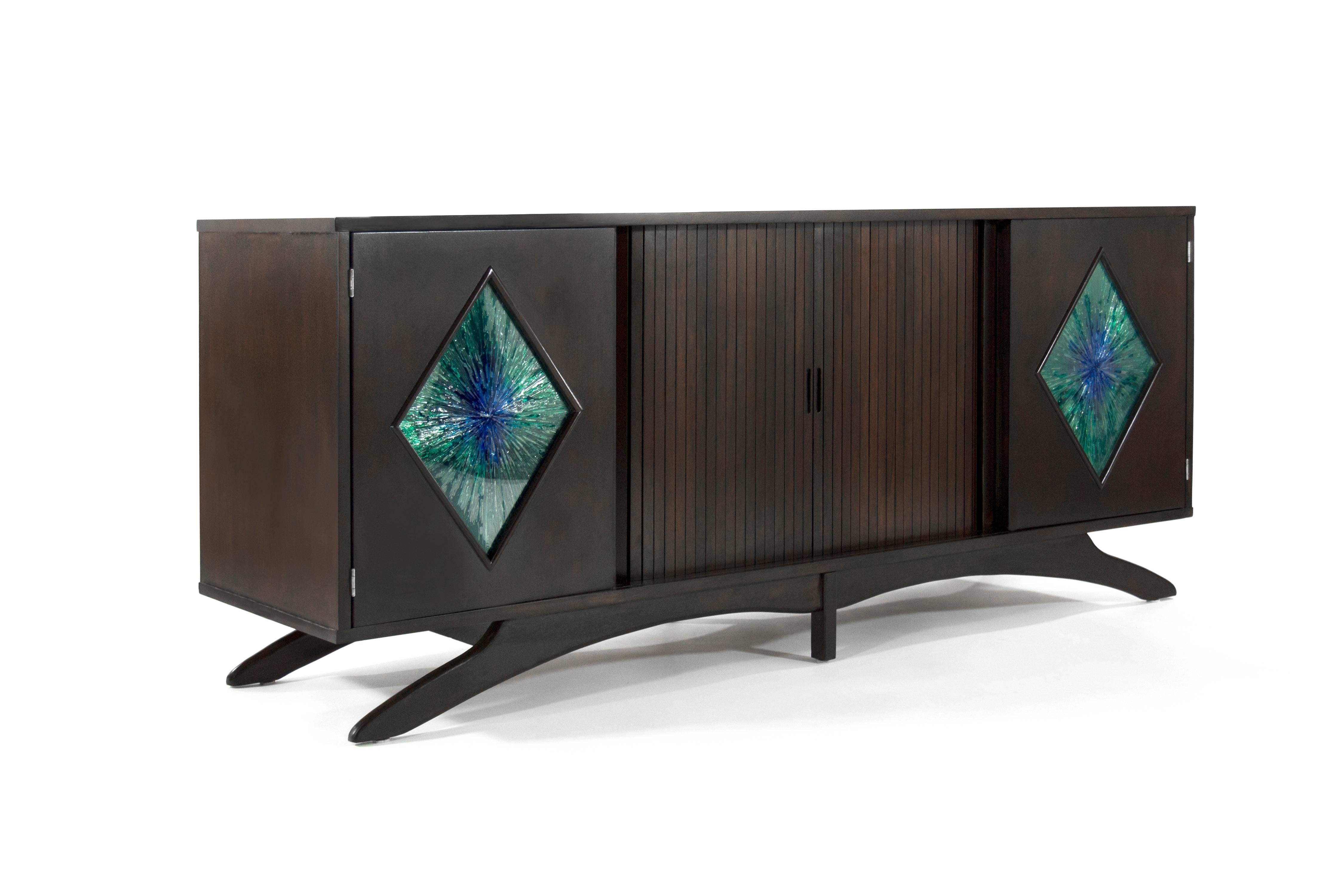 Stunning Mid-Century sculptural form credenza or sideboard with stained glass detail on doors.

Newly refinished in dark.