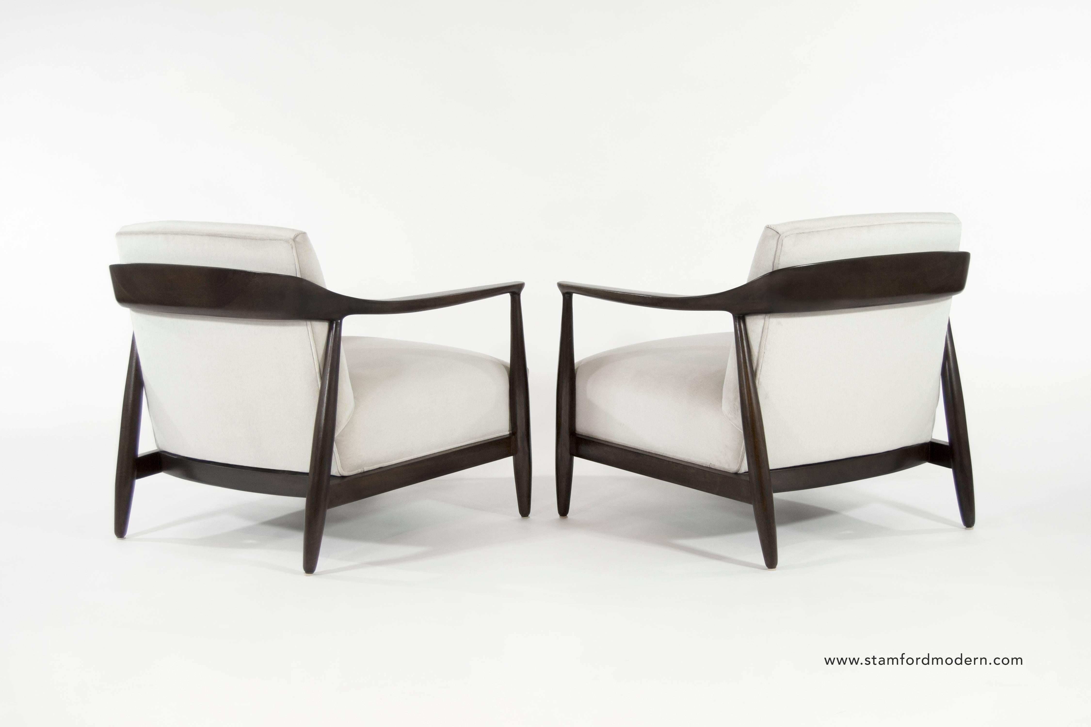 Pair of lounge chairs by Ib Kofod-Larsen, Denmark, circa 1950s. Sculptural walnut frames fully restored. Newly upholstered in light grey velvet.