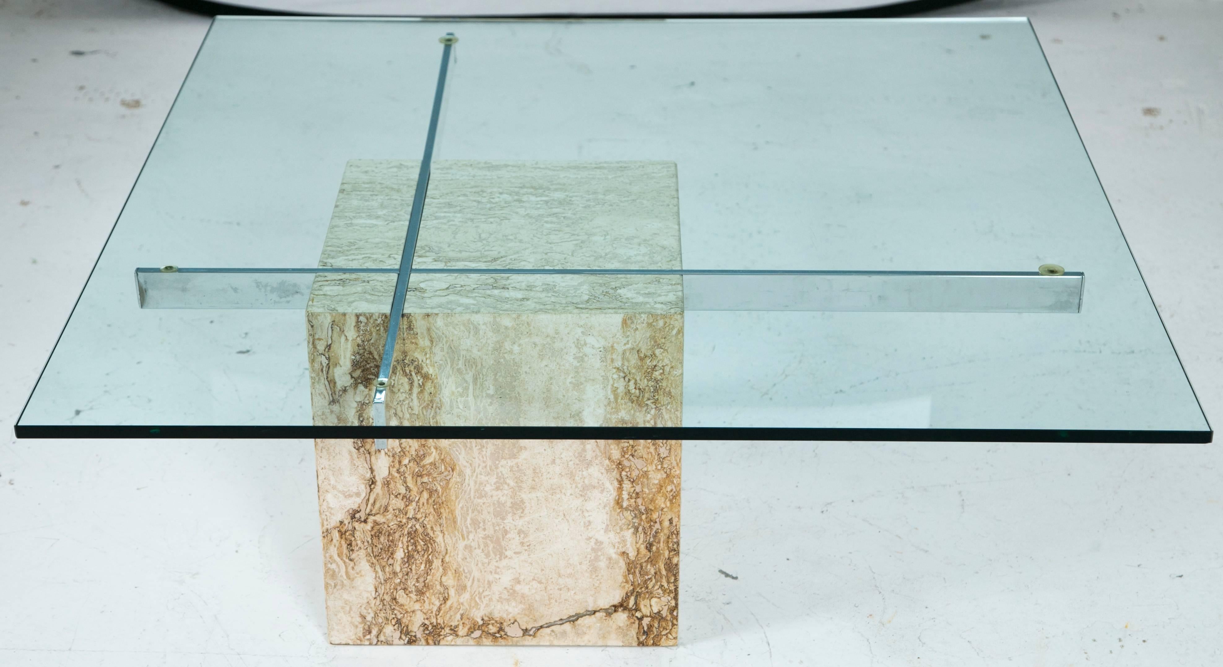 Minimalism is accentuated throughout this piece with careful use of material. One square travertine block grounds the piece both visually and physically. Chrome bars cantilever outward supporting a square piece of glass that sits strong on top.