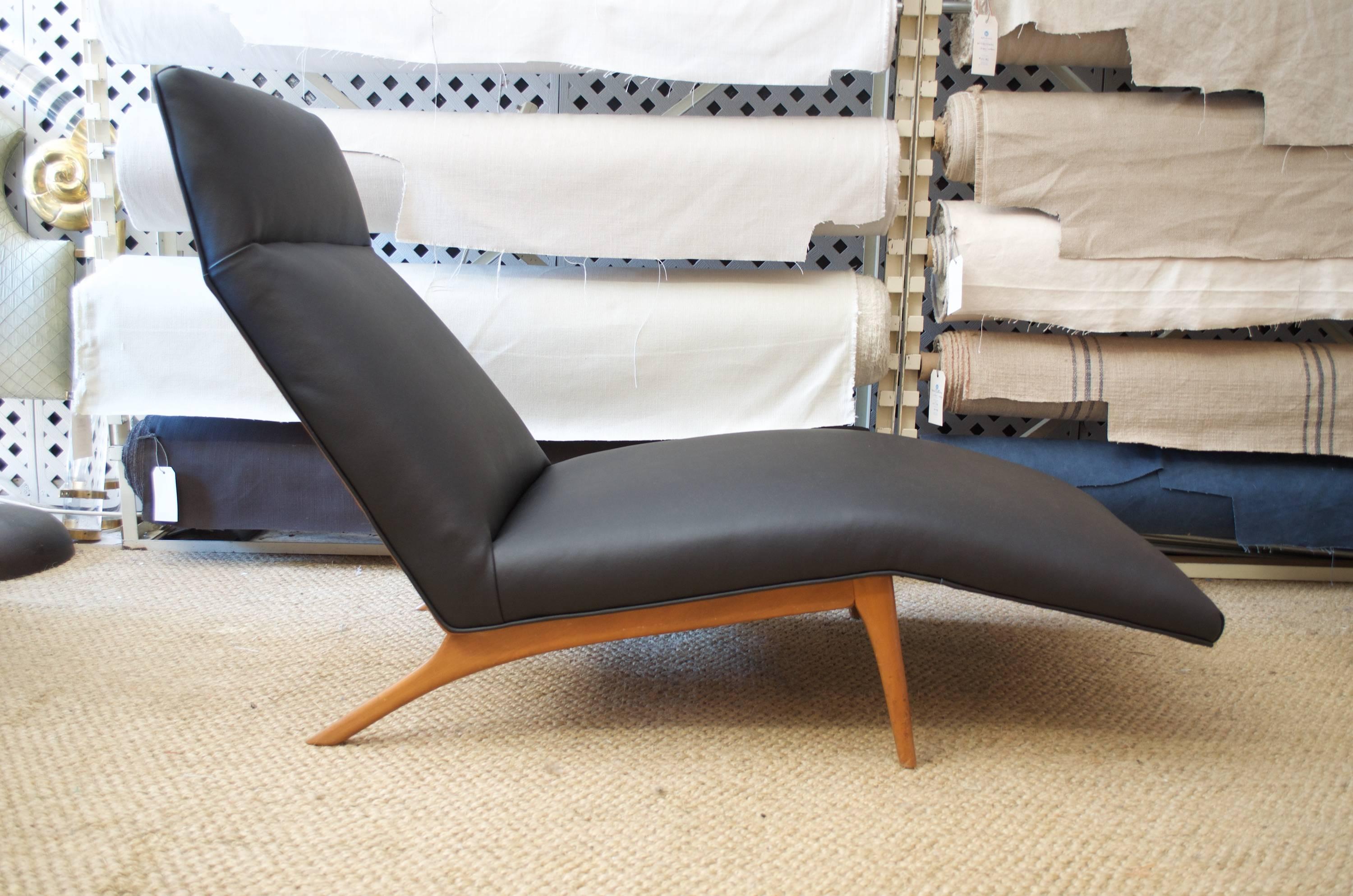 Rarely seen lounge chair designed by Poul Jensen for Selig. Phenomenally executed ergonomic design accommodates every body type. This piece has been newly upholstered using high grade contrasting leathers; a rich black on the front and an elegant