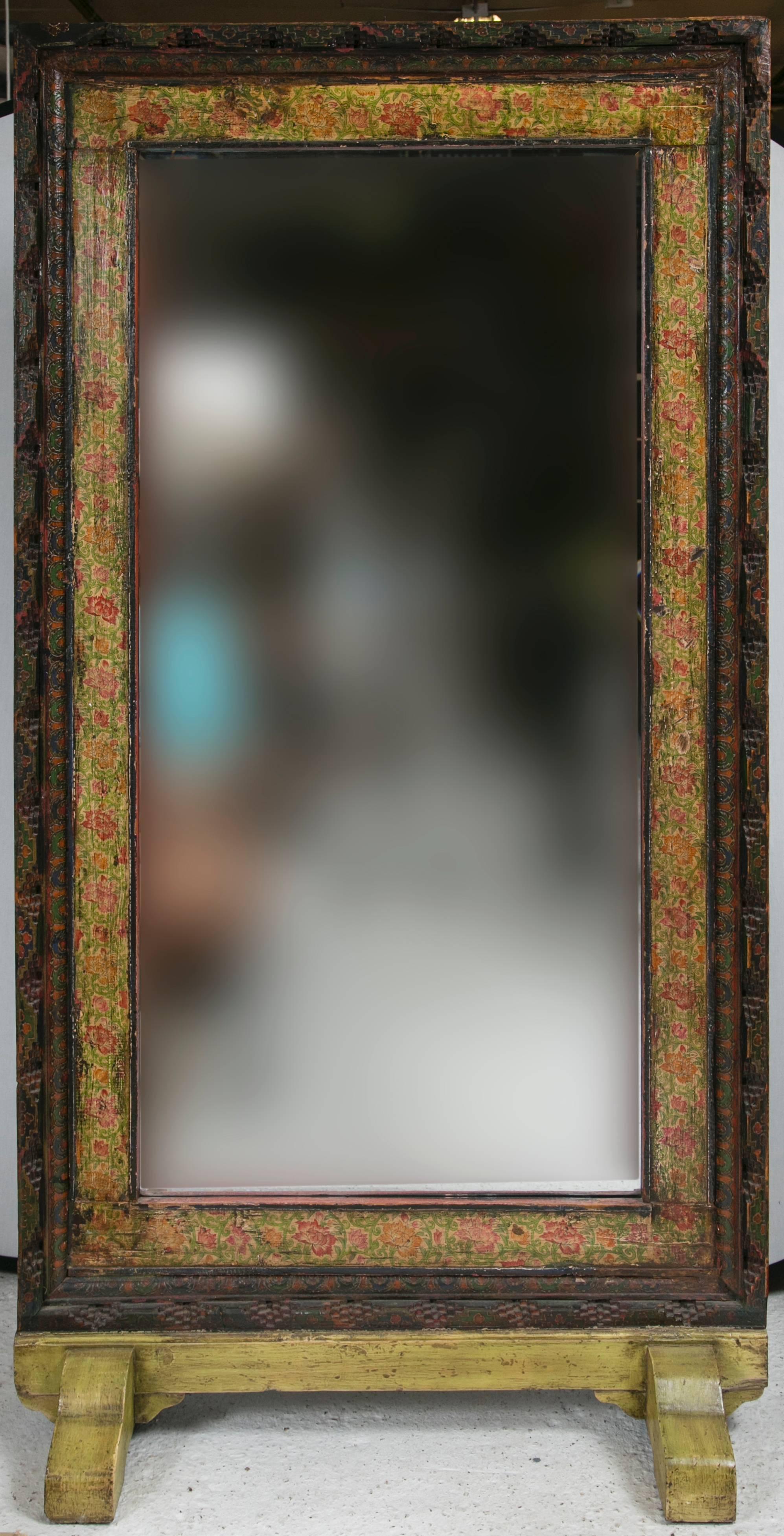 A one of a kind amazing example of a Tibetan antiquity. An exquisitely hand-painted and carved door transformed into a mirror, beauty and function in one. This piece is bold enough to make the biggest statement in a room as it is captivating from