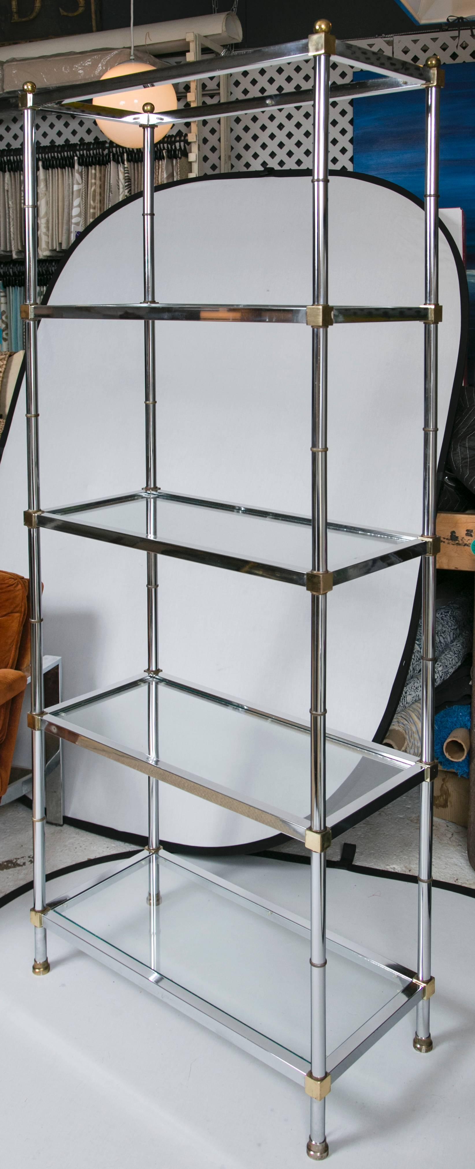 An excellently styled brass and chrome etagere in the Maison Jensen motif. Five shelves for optimal storage and display of your most cherished pieces. Well proportioned for a small space with plenty of room for storage.