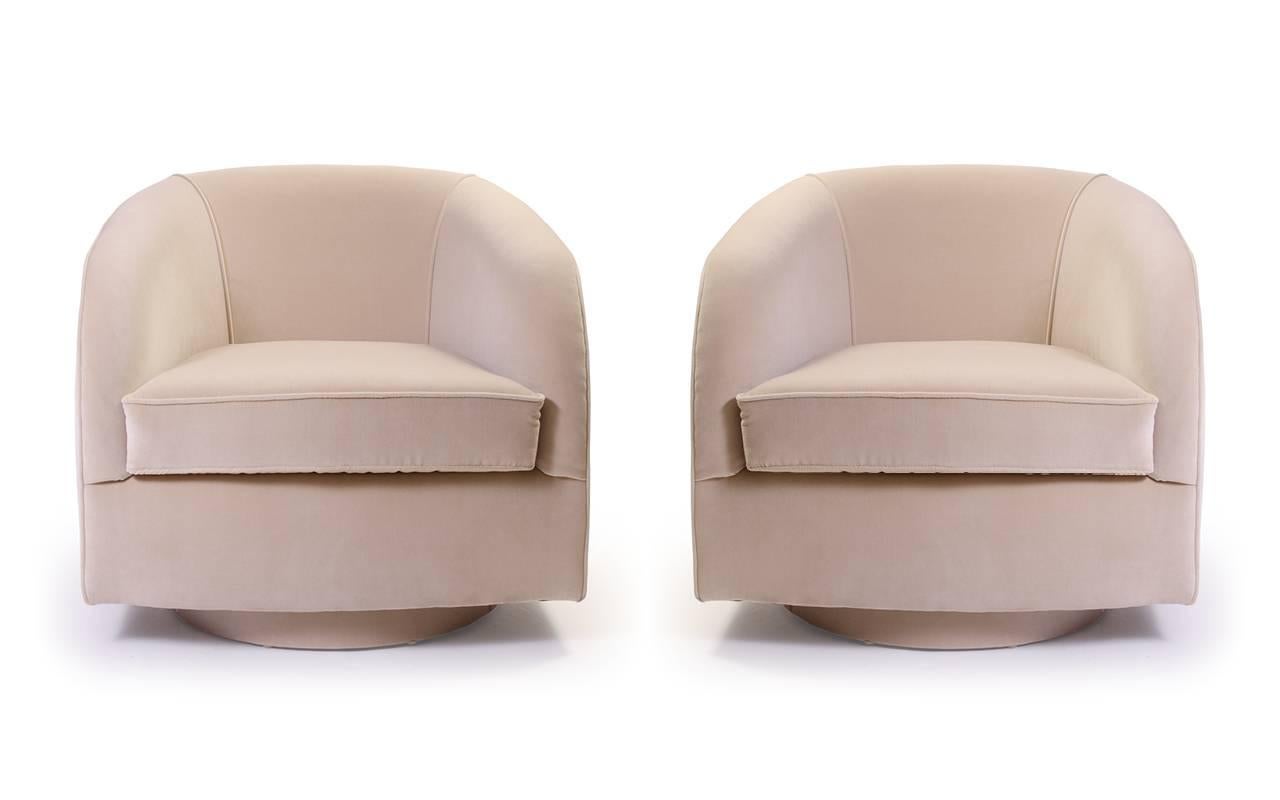 A stunning pair of Mid-Century swivel chairs, restored in house by the Montage workroom. Generously sized yet delicately proportioned, this pair works in a multitude of spaces. One continuous curve rises and swoops around back of the piece, then