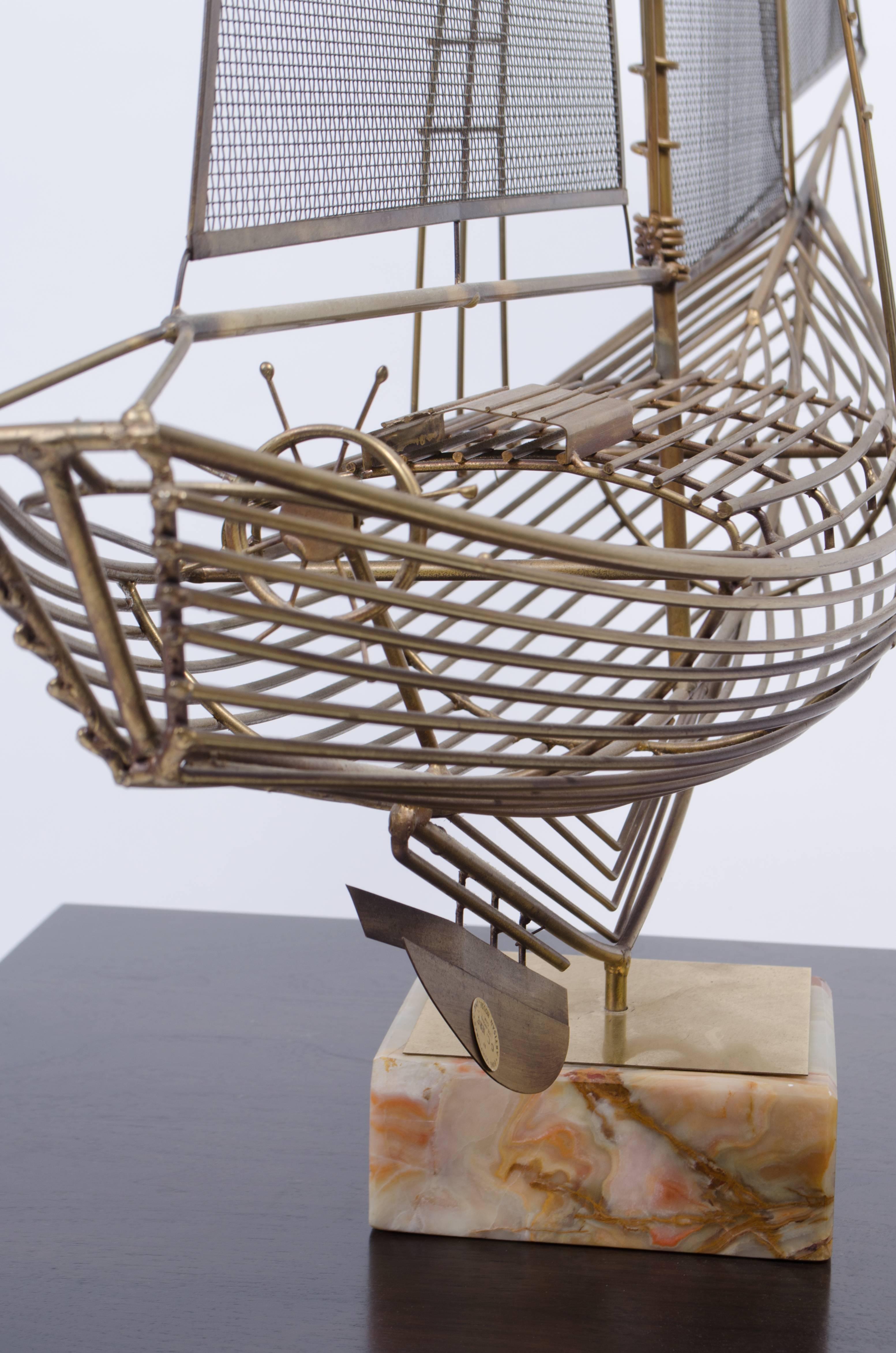 Pefection! Gaze at the intricacies of C. Jere's massive brass sail ship, countless rods frame negative space to form the wireframe of the grand vessel. Each sail is made from thin wire mesh, wonderfully done. The ship is mounted upon a polished onyx