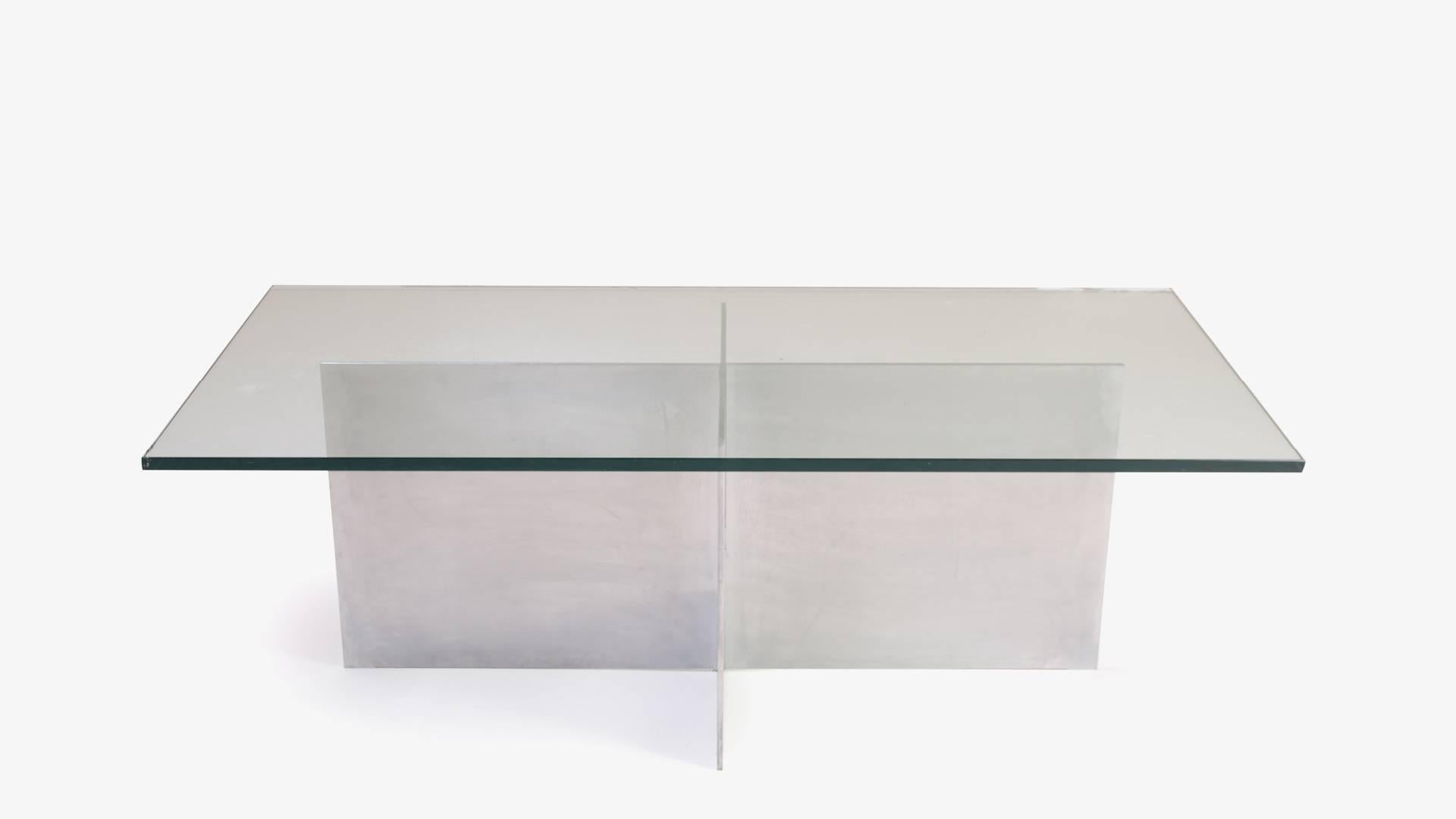 An elegant Minimalist design entirely from 3 planes of material; 2 of metal and the third of glass. Two metal planes cross together to form the base of this elegant table, subtle in profile but bold in materiality. Original Knoll glass is used to