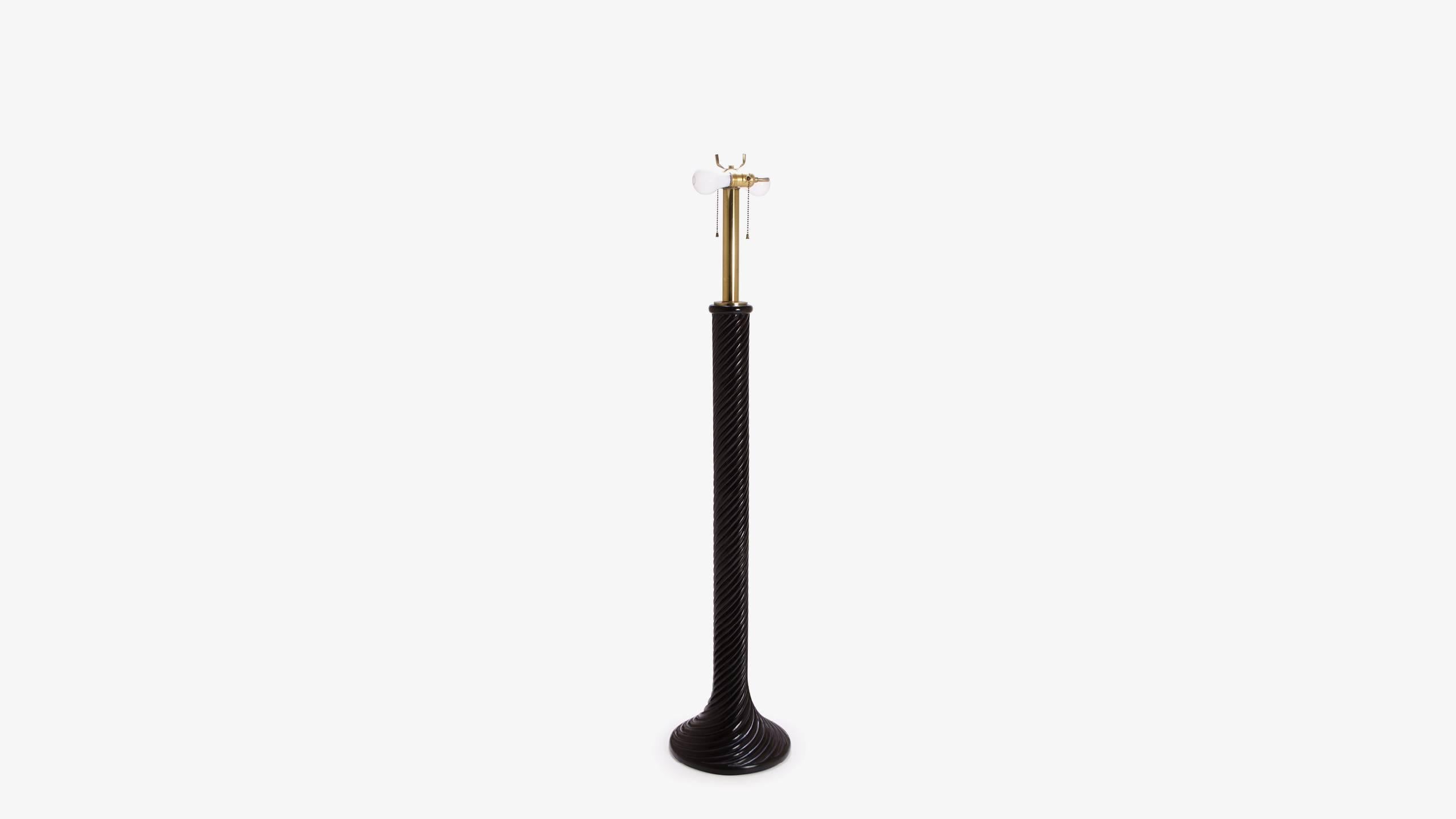 A great example of Hollywood design with ebonized resin in the Classic swirl motif common for the era. Starting from it's flared base, the floor lamp twirls upwards with its glossy ebony resin finish to meet brass hardware. The lamp is equipped with