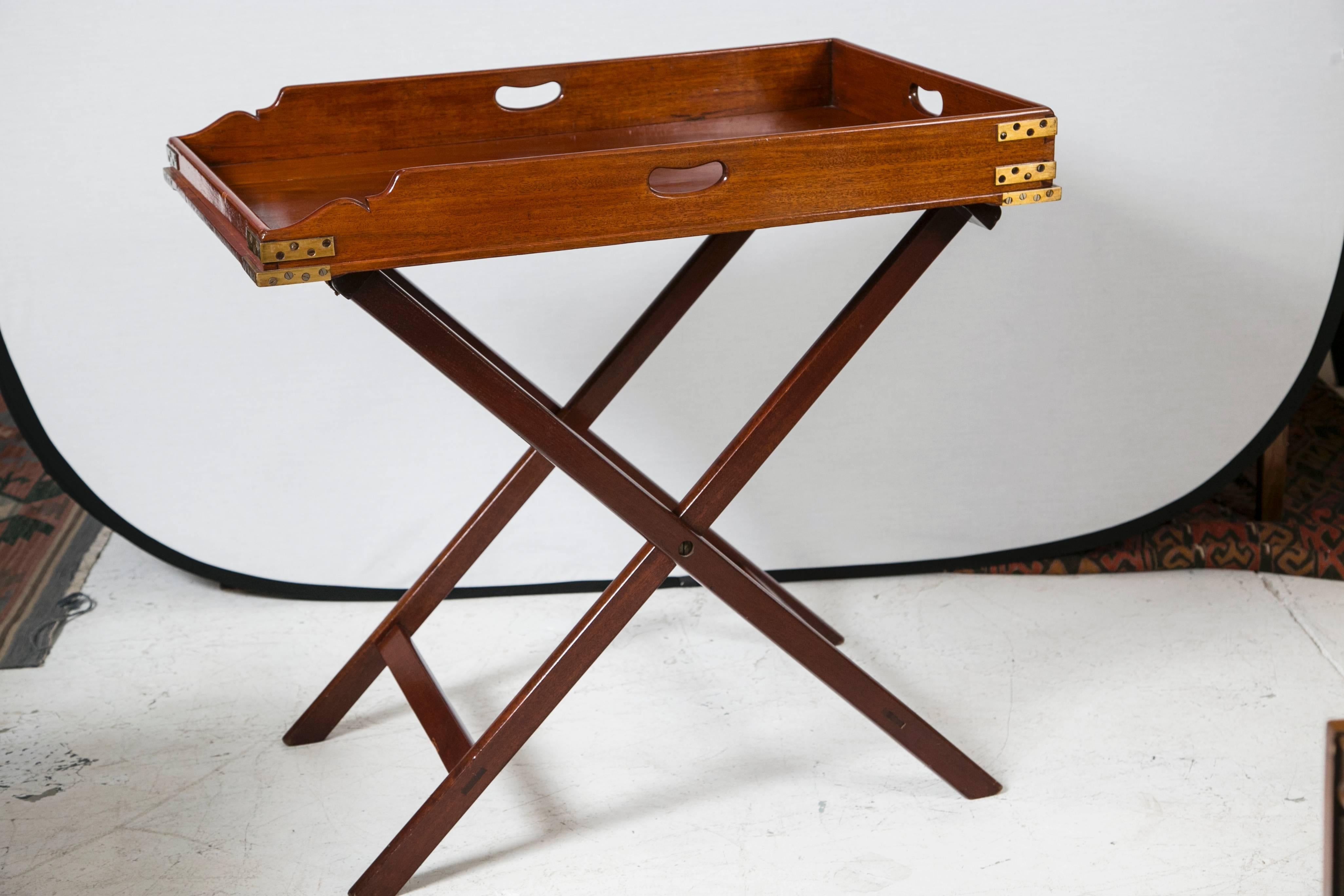 Antique Butler's tray table with handmade brass accents. The details have the beautiful softness of age. Made of mahogany with a brilliant range of color and grain. Original straps hand-hammered with handmade nails. A rare beauty!