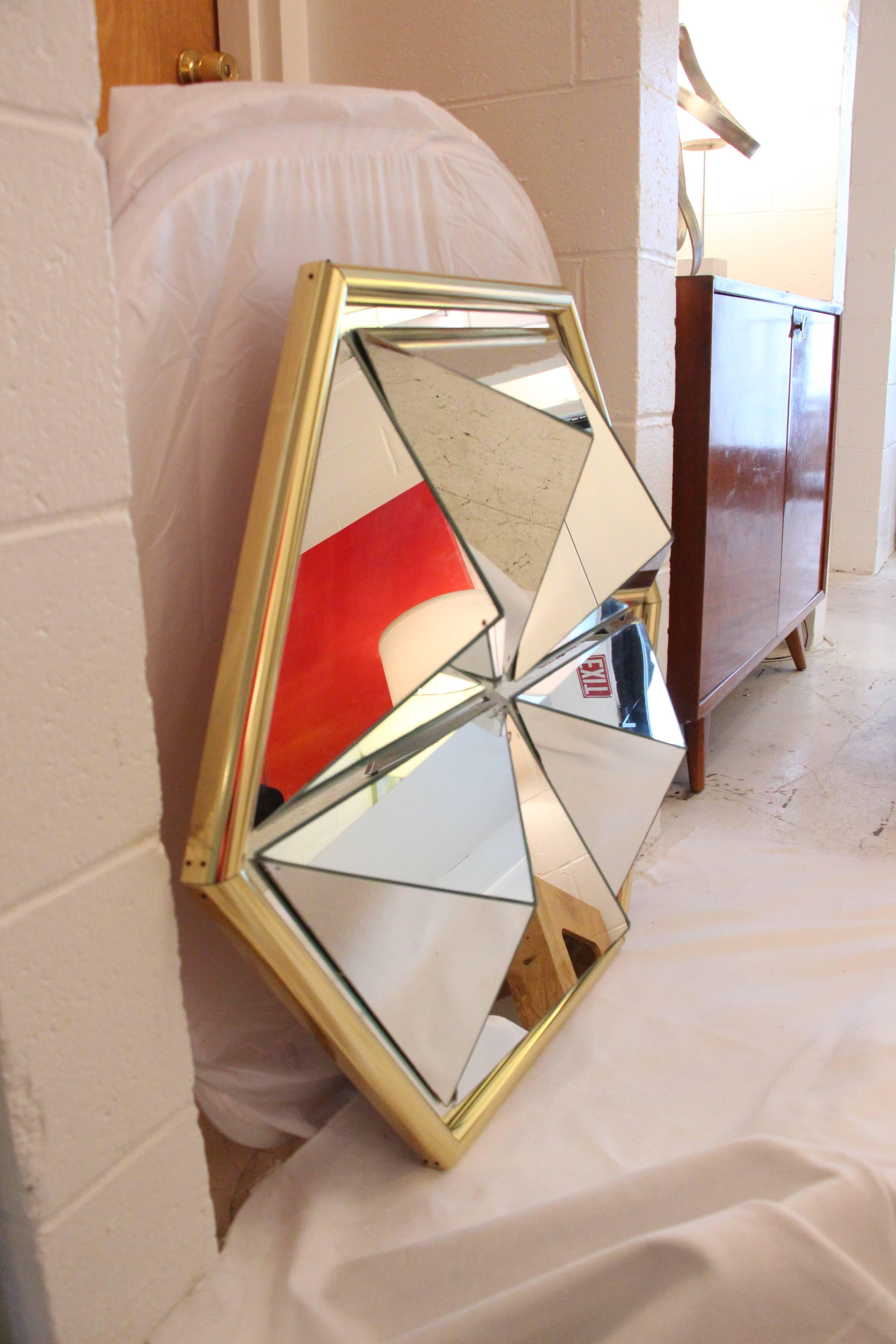 Fantastic prism mirror with a heavy brass sculpted frame. Geometric faceted panels give the mirror 5' of depth. There are some age spots on a few of the panels but in our opinion it adds interest.