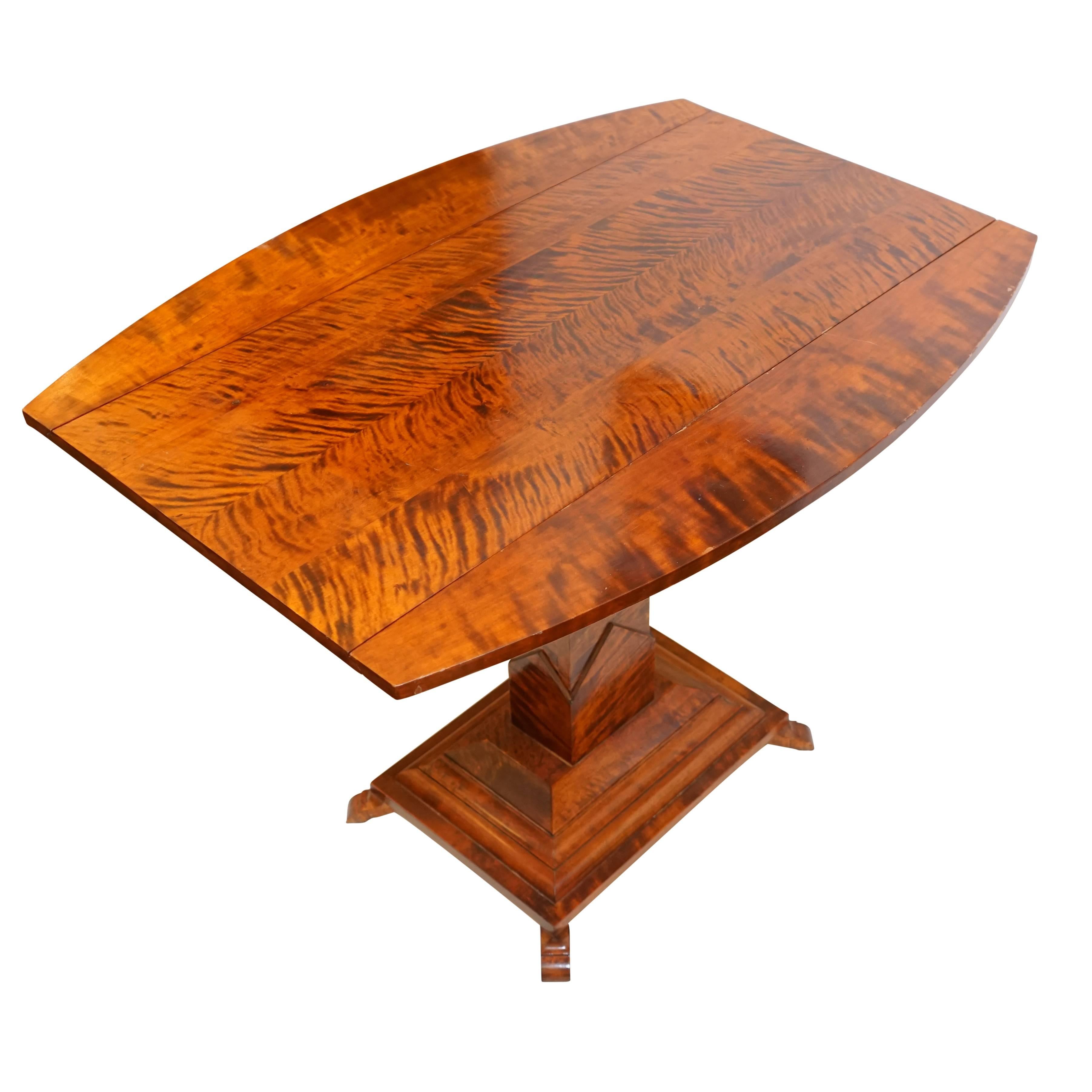 A slim console which opens to seat four, this solid birch table retains its original warm, walnut stain. A handsome addition to a dining alcove, the table features unique geometric features on its pedestal base and measures 29.5