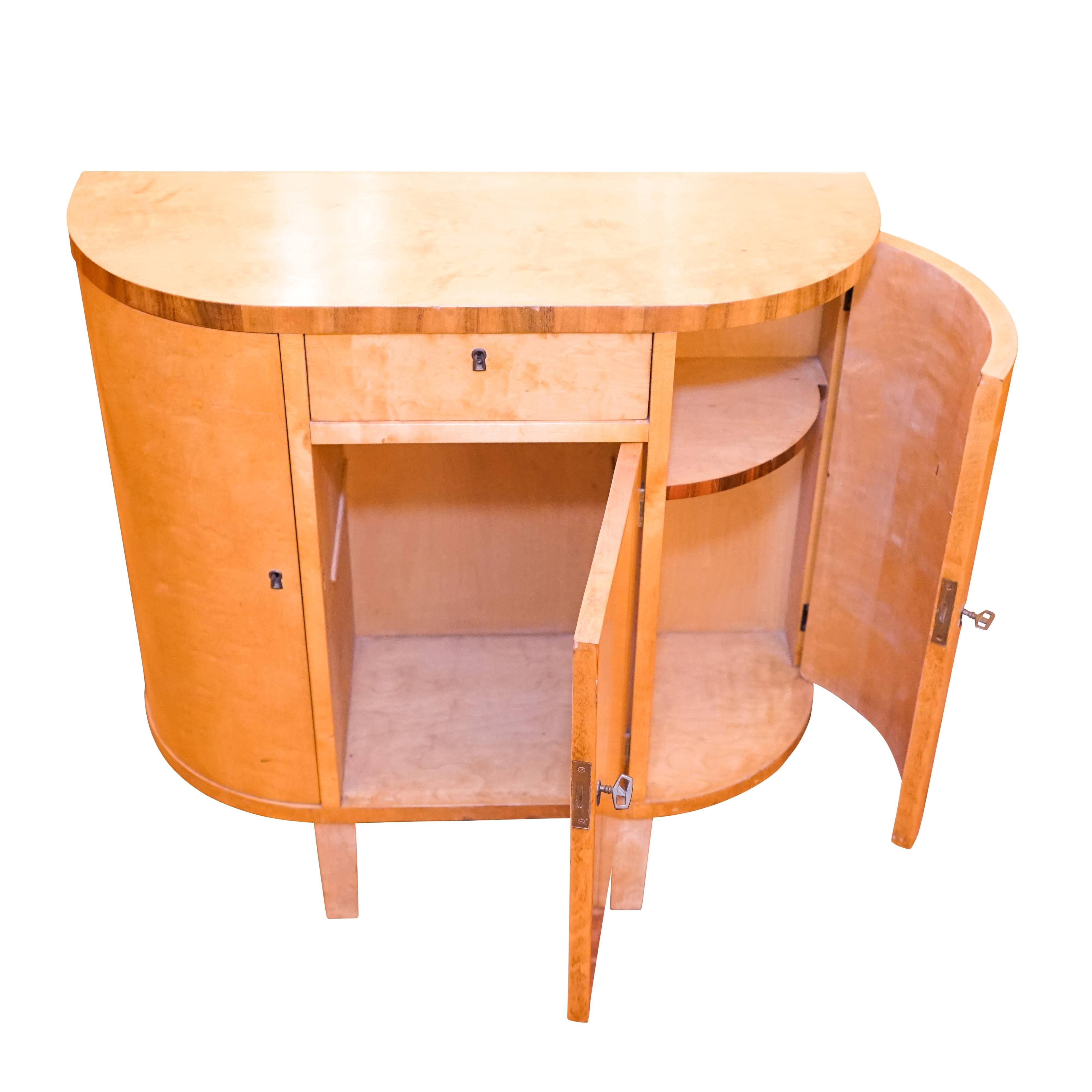 Perfect for a short wall or a small space, this console packs a lot of storage along with sleek Art Deco style! Constructed of solid fir and birch and veneered with choice nordic birch with rosewood banding, all compartments as well as the center