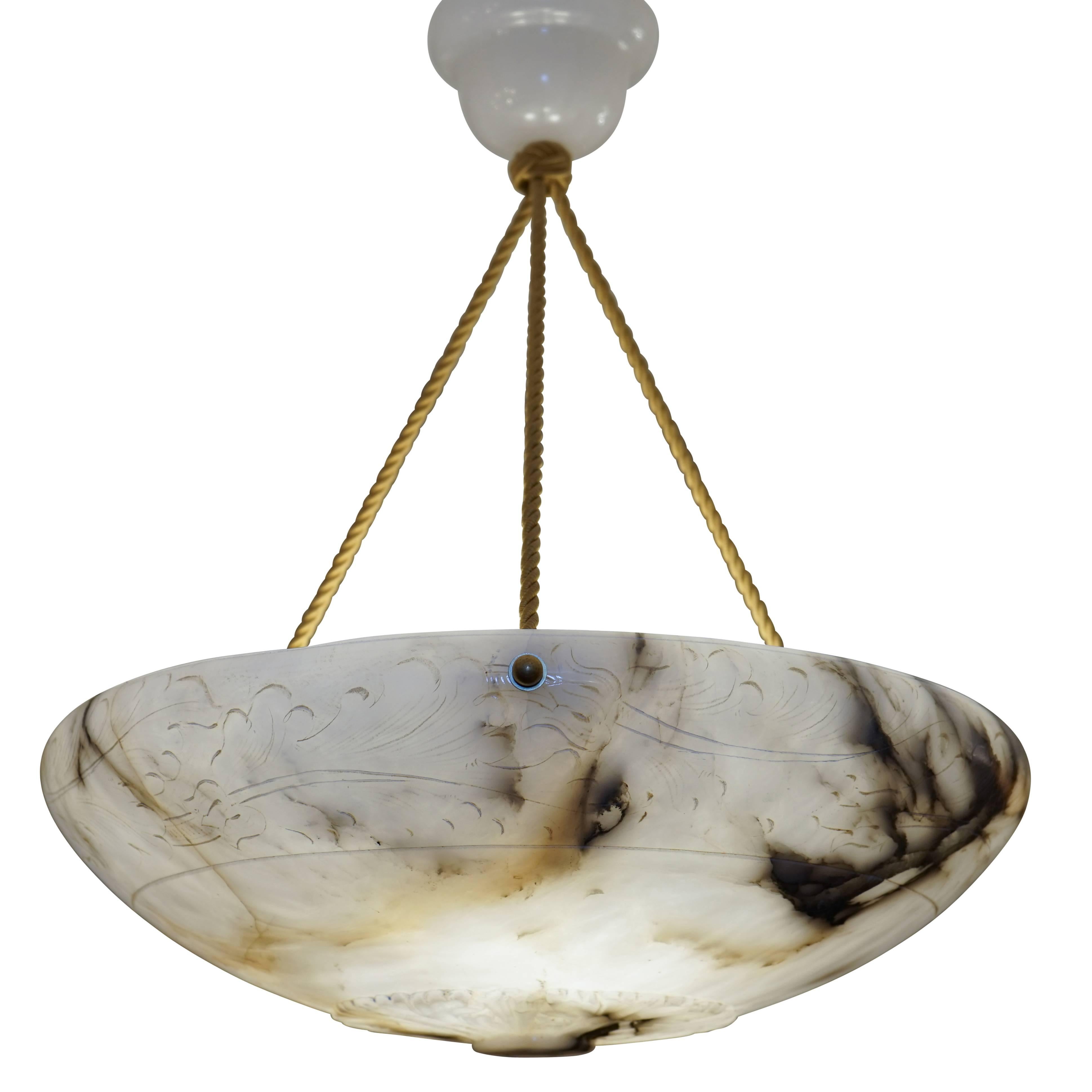 A lovely fixture, featuring discreet carving around a full upper band, a base medallion, and dramatic, multi-toned mineral veining. Recently rewired, the light holds three 60 watt incandescent bulbs, or three LED bulbs of any wattage equivalence.