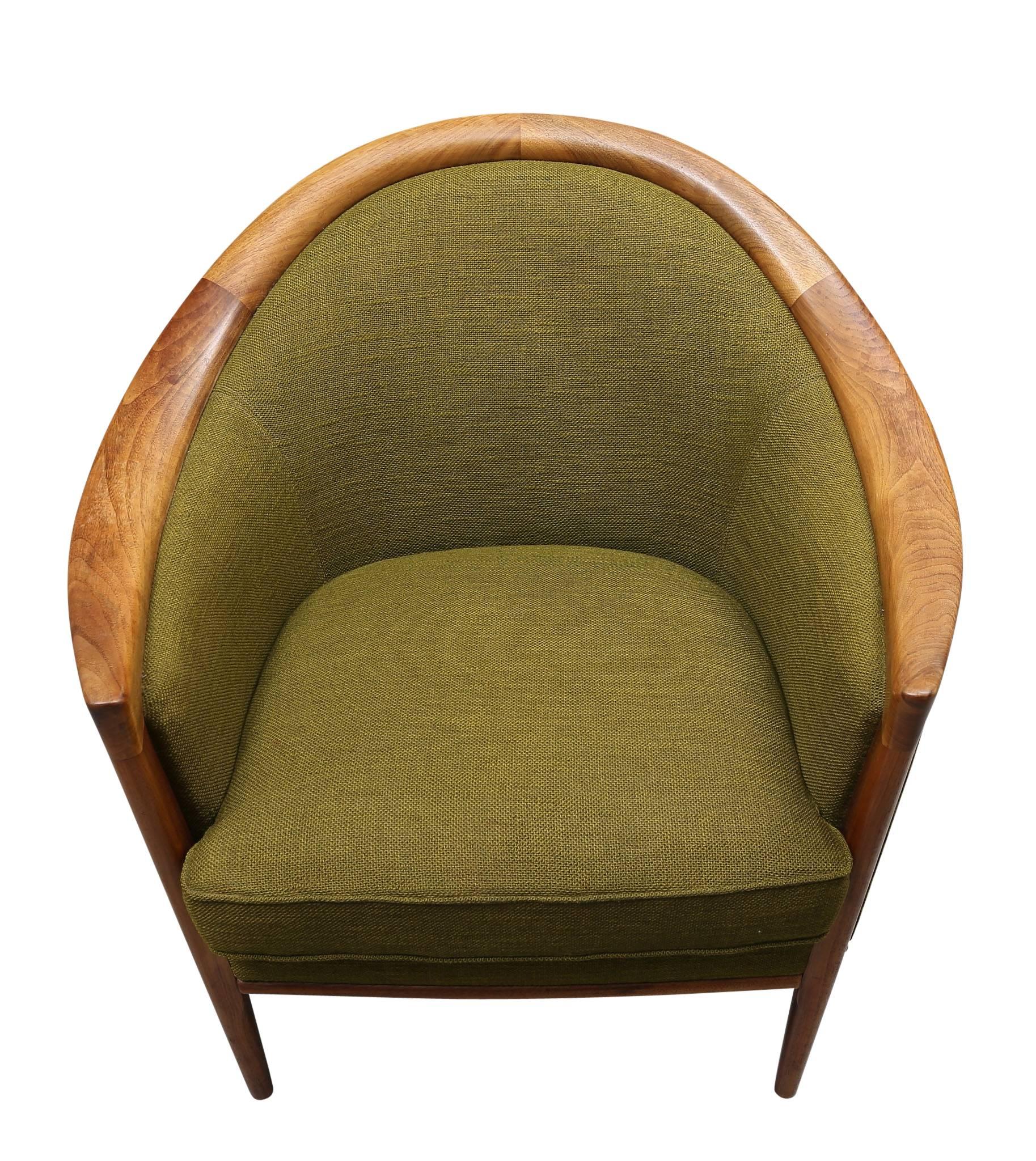 Comprising a sleek three-seat sofa and a matching armchair, the group is offered in its original, vintage green tweed fabric. An additional pair of matching chairs are also available. Re-upholstery is suggested, at an additional charge; however,