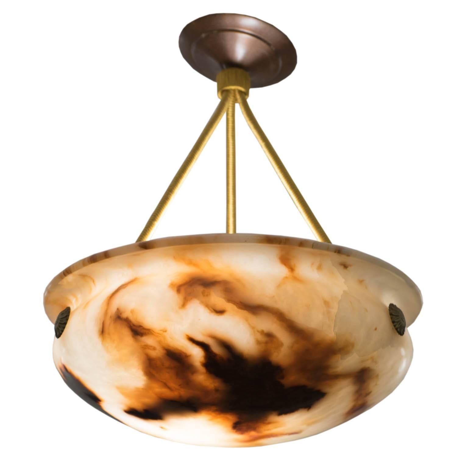 This type of alabaster is rarely seen and exists only in antique pieces. The creamy, curved bowl is swirled with warm clay-toned mineral deposits and has been polished to a high gloss. Original bronze medallions anchor the electrified ropes to the