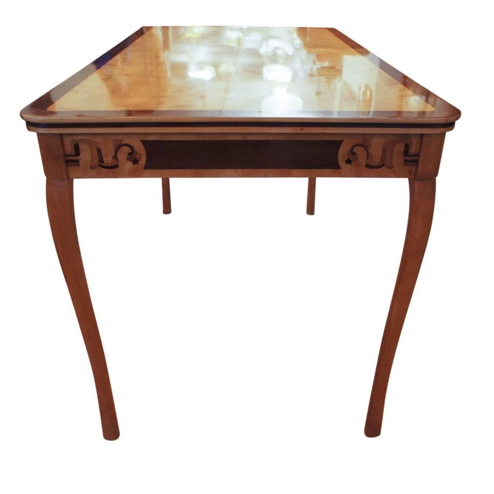 Graceful and gleaming, this table doubles as a desk for inspiration or a dining table for an elegant alcove. Predominantly golden birch, with inlays of mahogany, ash and palisander, the table dates from the 