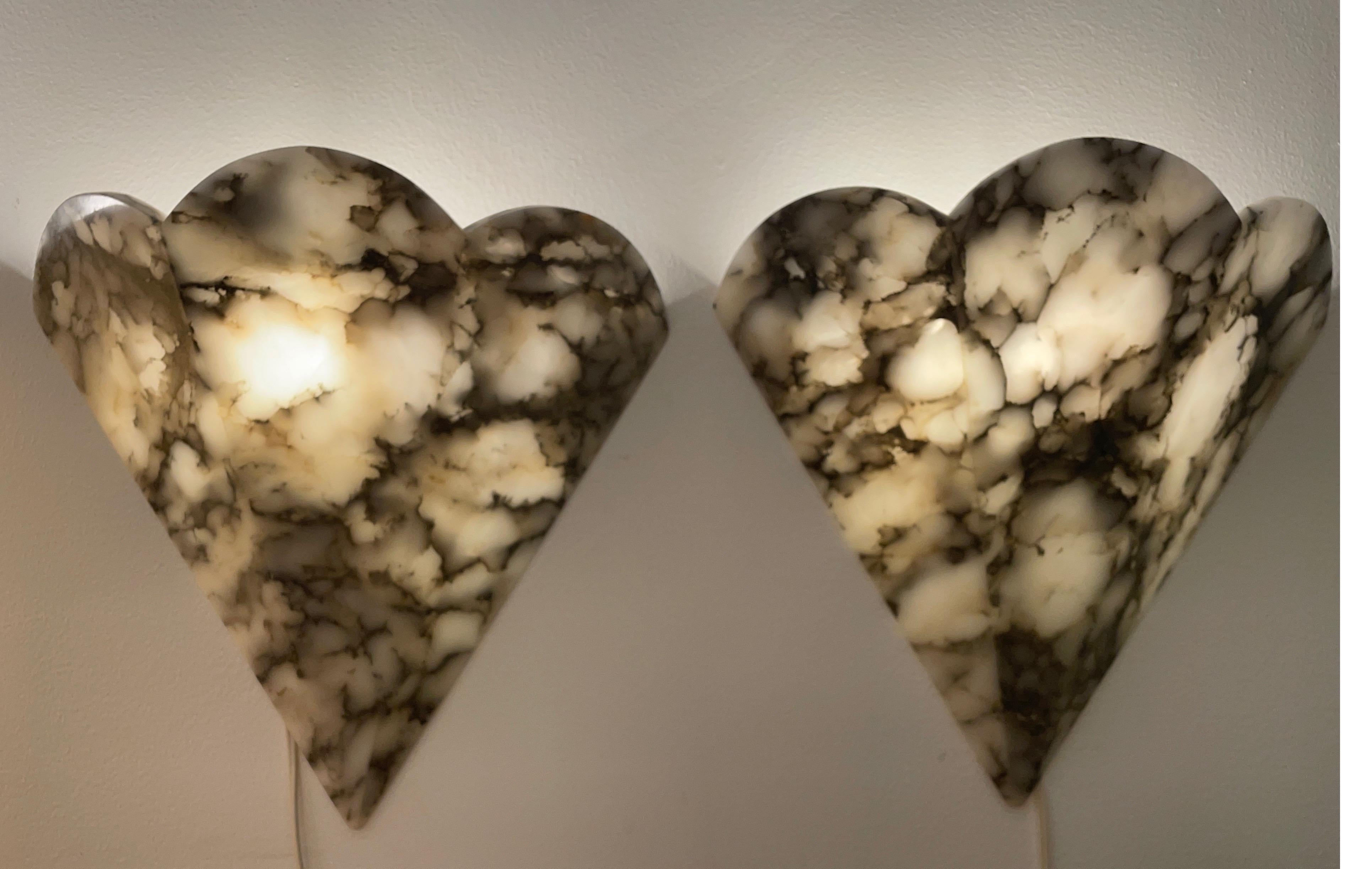 Although this is actually a set of six pieces, we are offering these unusual and beautiful sconces in pairs. Diamond-shaped, yet scalloped, they were created from highly veined white alabaster, and hold one 60 watt bulb each.