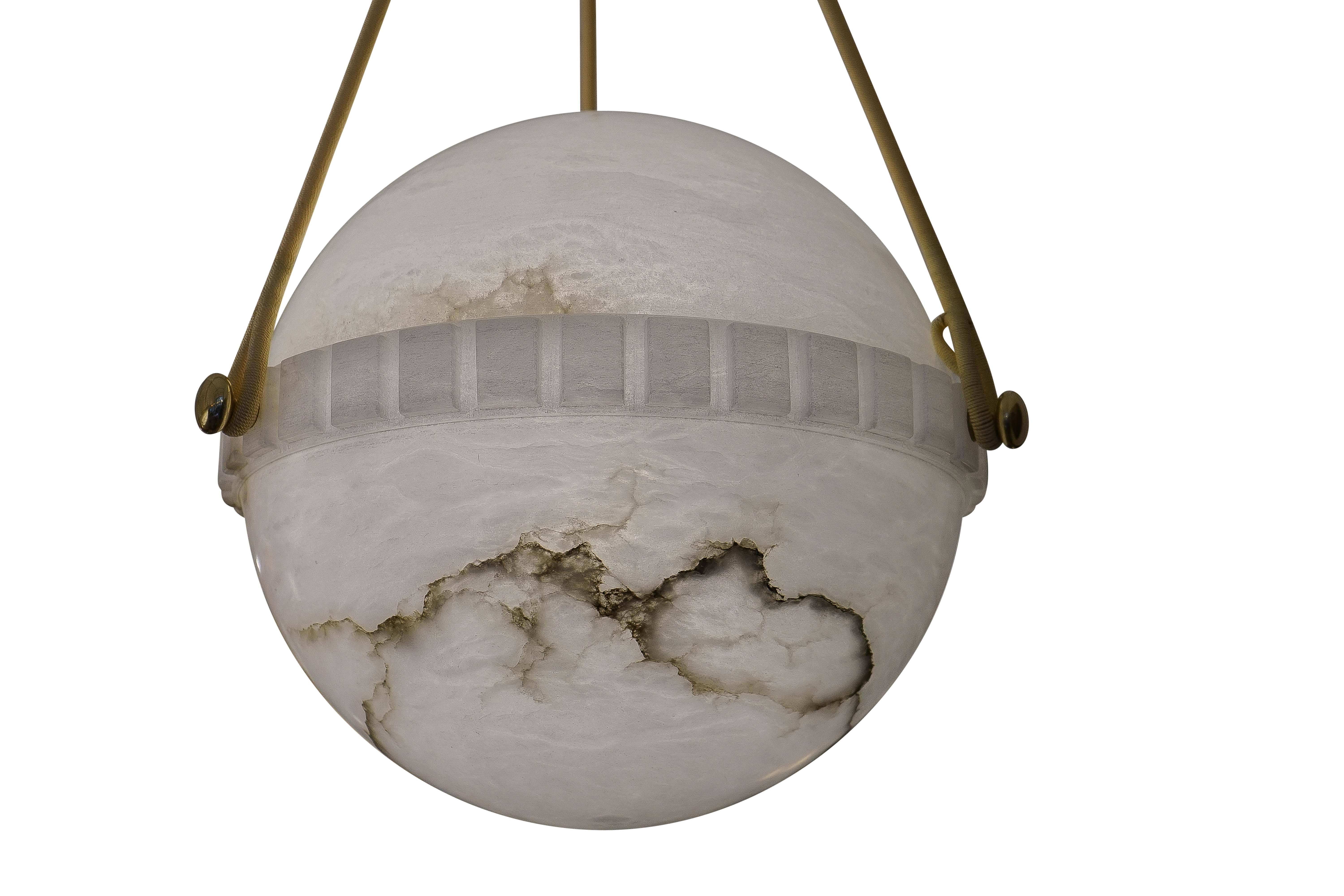 More unusual than the bowl shaped pendants, the globe alabaster features a lower half with a crisp dental motif on the central band and suspends on a set of three brushed nickel flattened balls.  The upper half nestles perfectly into the banding and