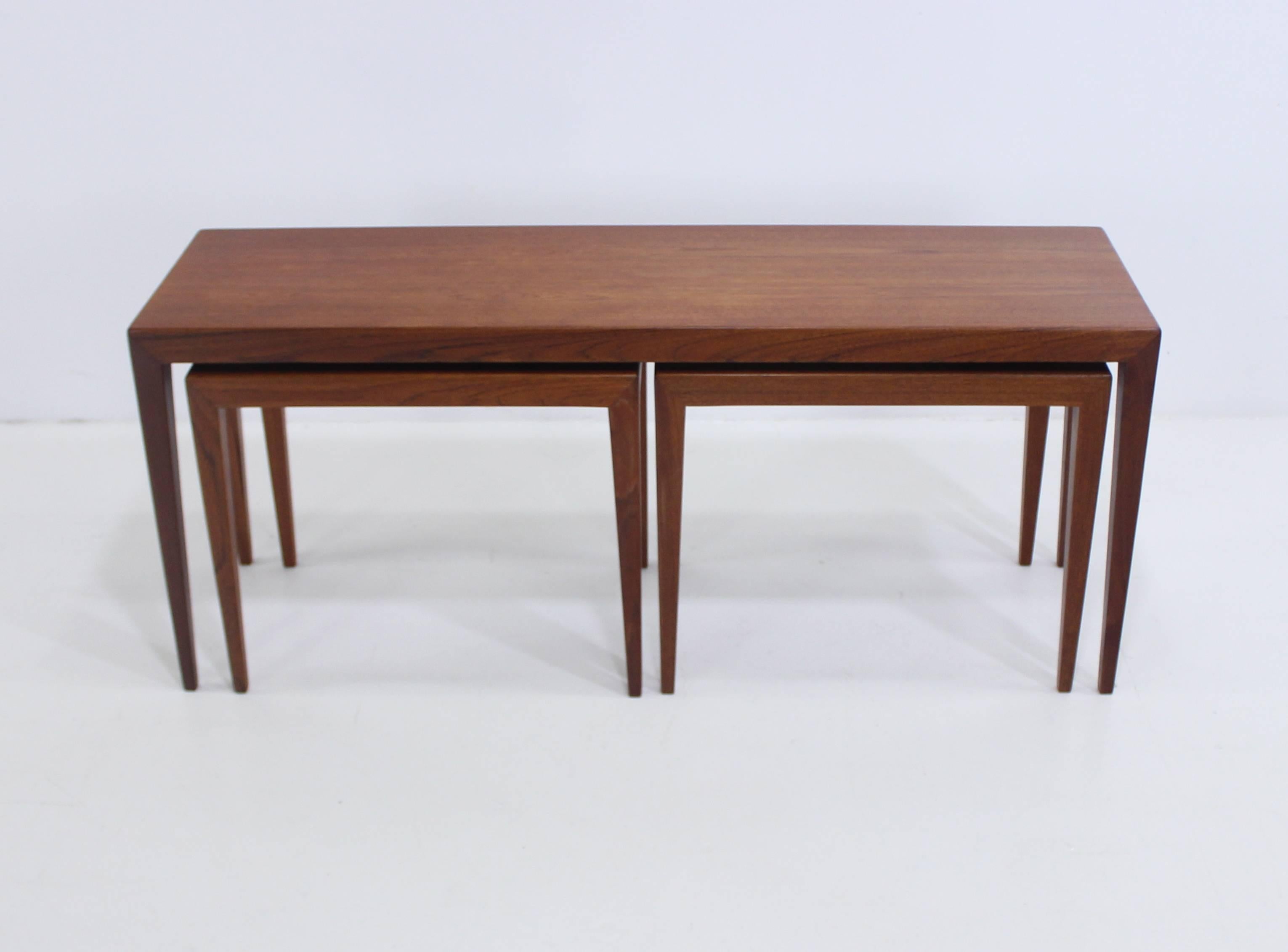 Three nesting tables designed by Severin Hansen.
Matchless Minimalist style.
Two smaller tables measuring 19.5" W x 12.5" D x 16.25" H, neatly slide under larger table.
Richly grained teak.
Beautifully beveled