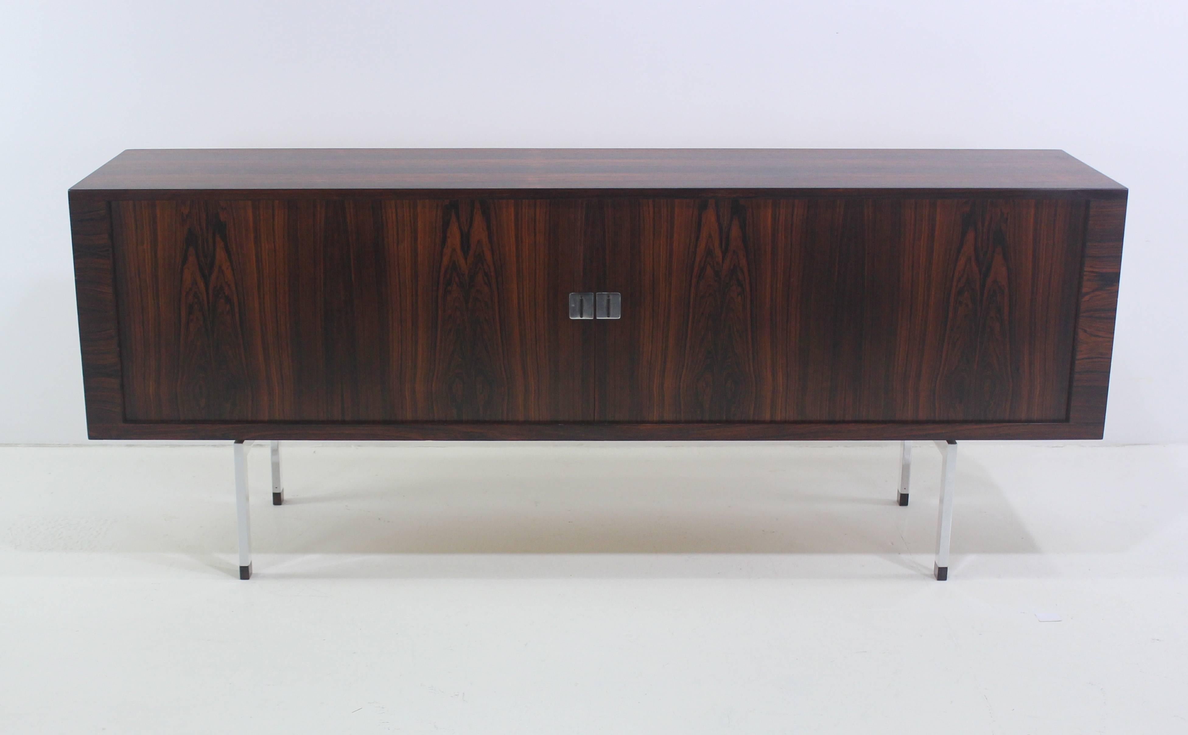 Danish modern credenza designed by Hans Wegner.
A timeless Classic made in the late 1950s by Ry Mobler.
Richly grained wraparound rosewood. Oak interior.
Polished steel legs with rosewood socks.
Tambour doors with extraordinary square pulls