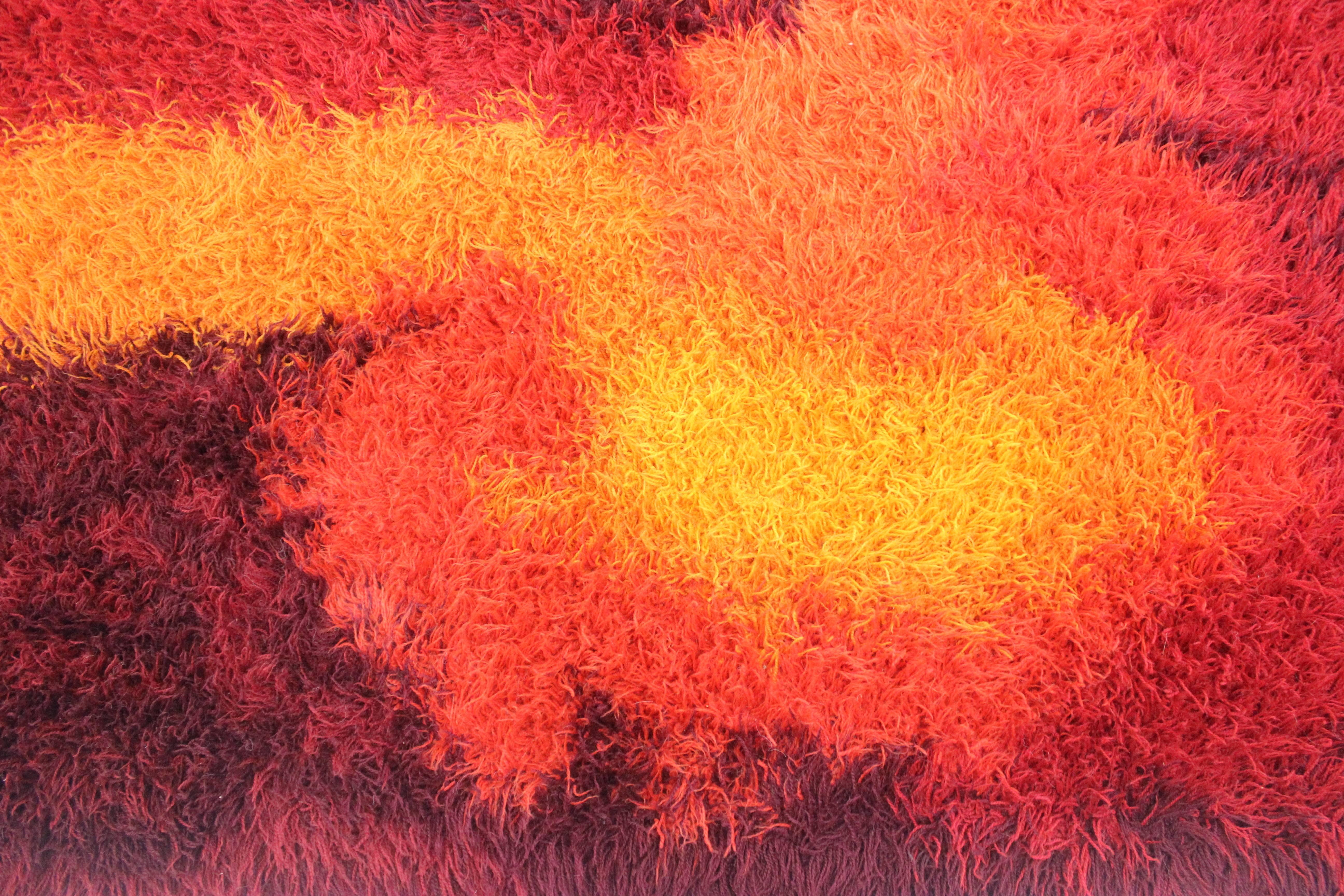 Rya rug with a mix of intense, saturated colors, lighting any space with vibrance and energy. 
Central radiating pattern features brilliant reds, oranges and yellows on a dark burgundy field. 
100% wool.
Matchless quality and price.
Low freight