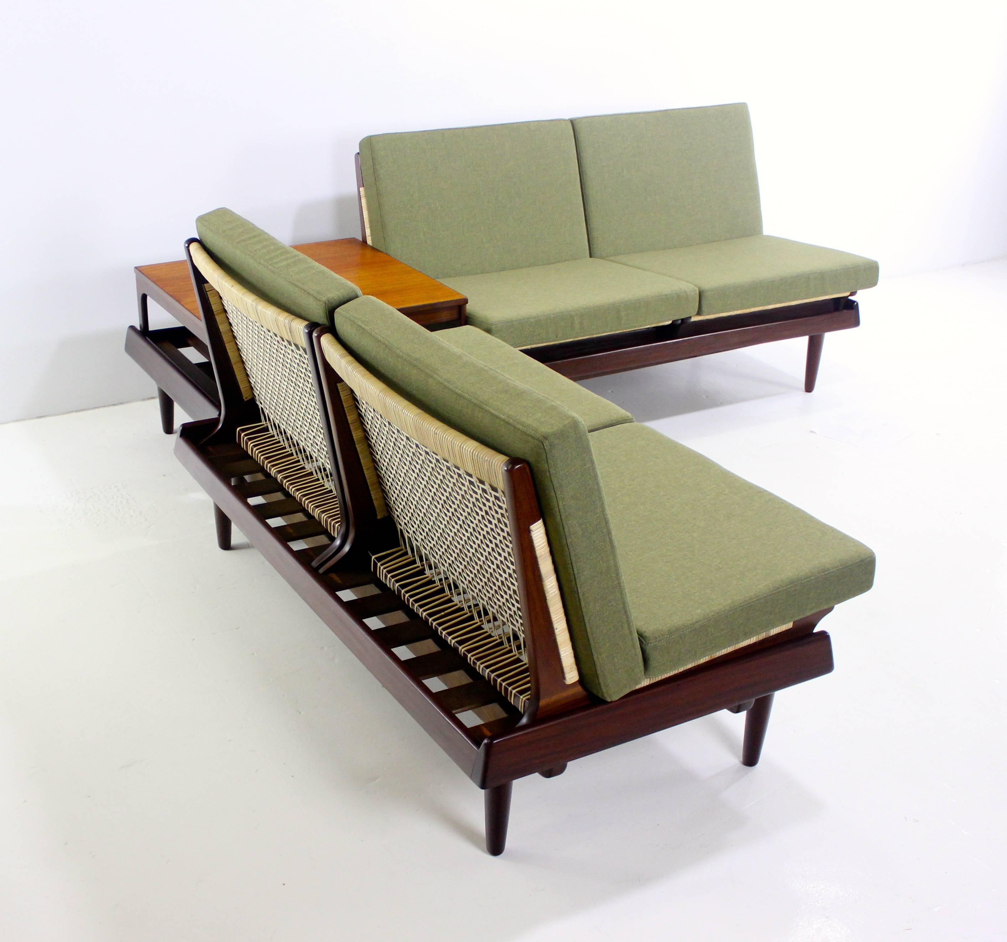 Danish modular seven-piece seating group designed by Hans Olsen.
Bramin, maker.
Composed of one sofa and one settee unified by integrated corner table.
Breaks down to two benches, four chairs and one low table.
Eight interchangeable cushions