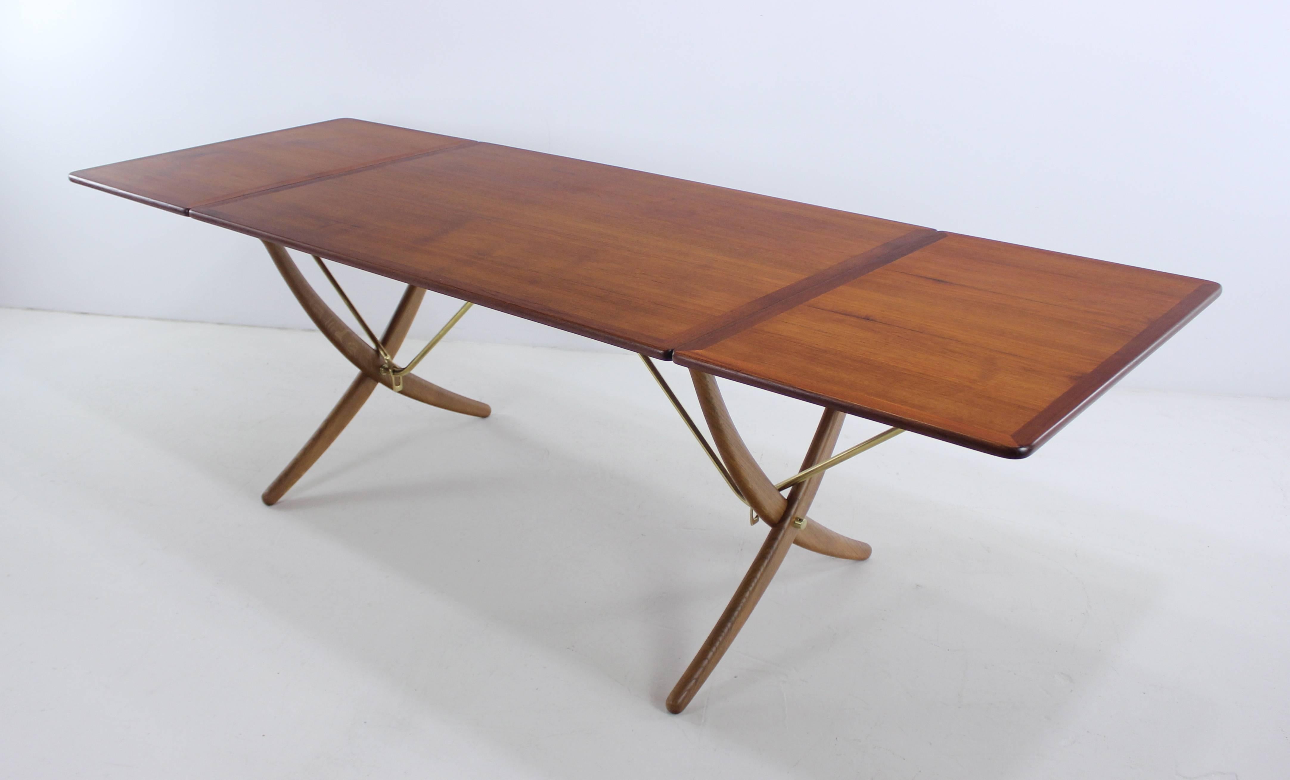 Danish modern dining set designed by Hans Wegner, circa 1951.
Andreas tuck, table maker.
Richly grained teak top, dramatic oak saber style legs and brass hardware.
Table measures 52" W x 33.75" D x 28.5" H.
Drop leaves on each end