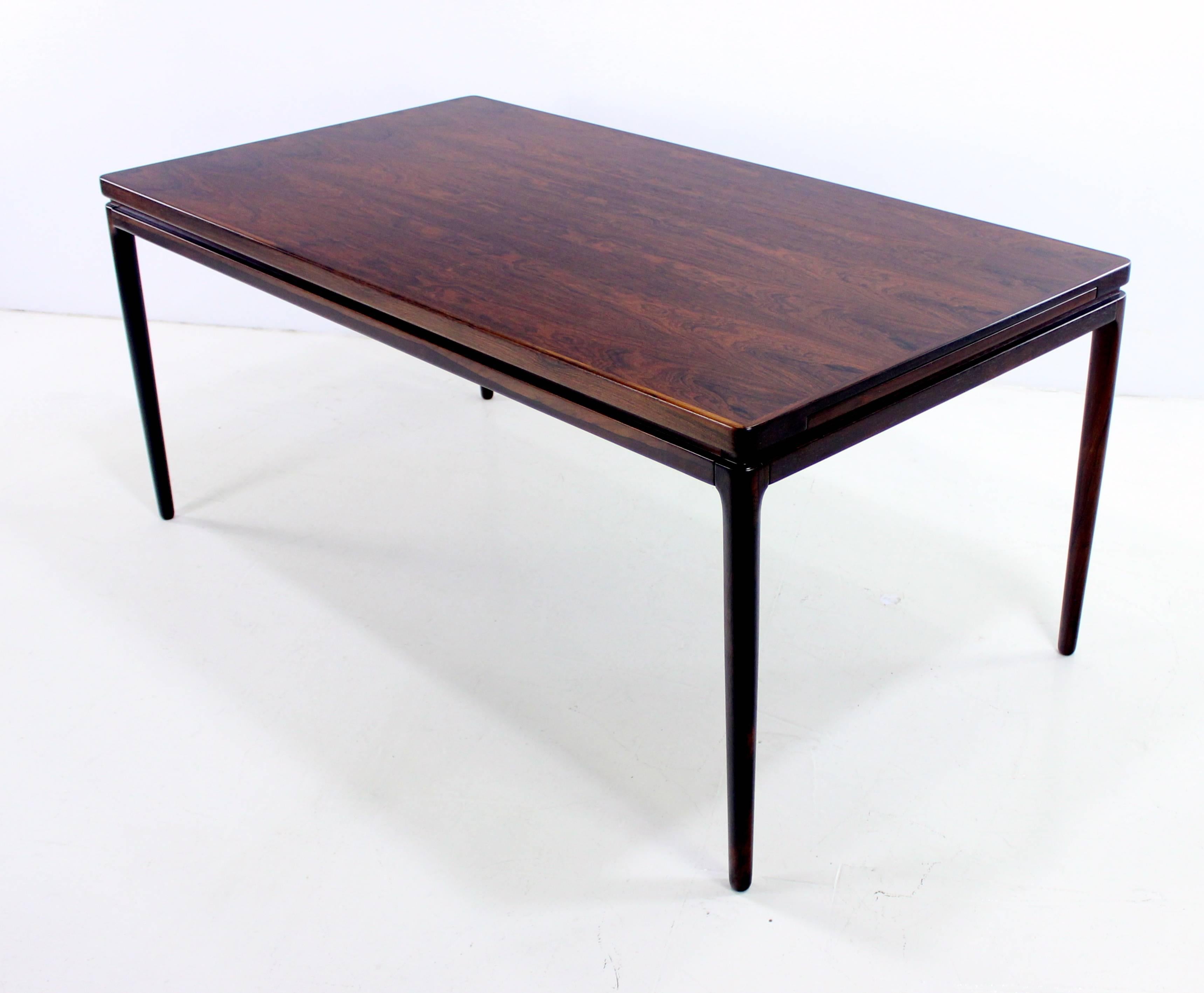 Danish modern dining table designed by Johannes Andersen.
Christian Linneberg, maker.
Richly grained rosewood.
Exceptional style, joinery and craftsmanship.
Two pull-out leaves store under table and provide full extension of