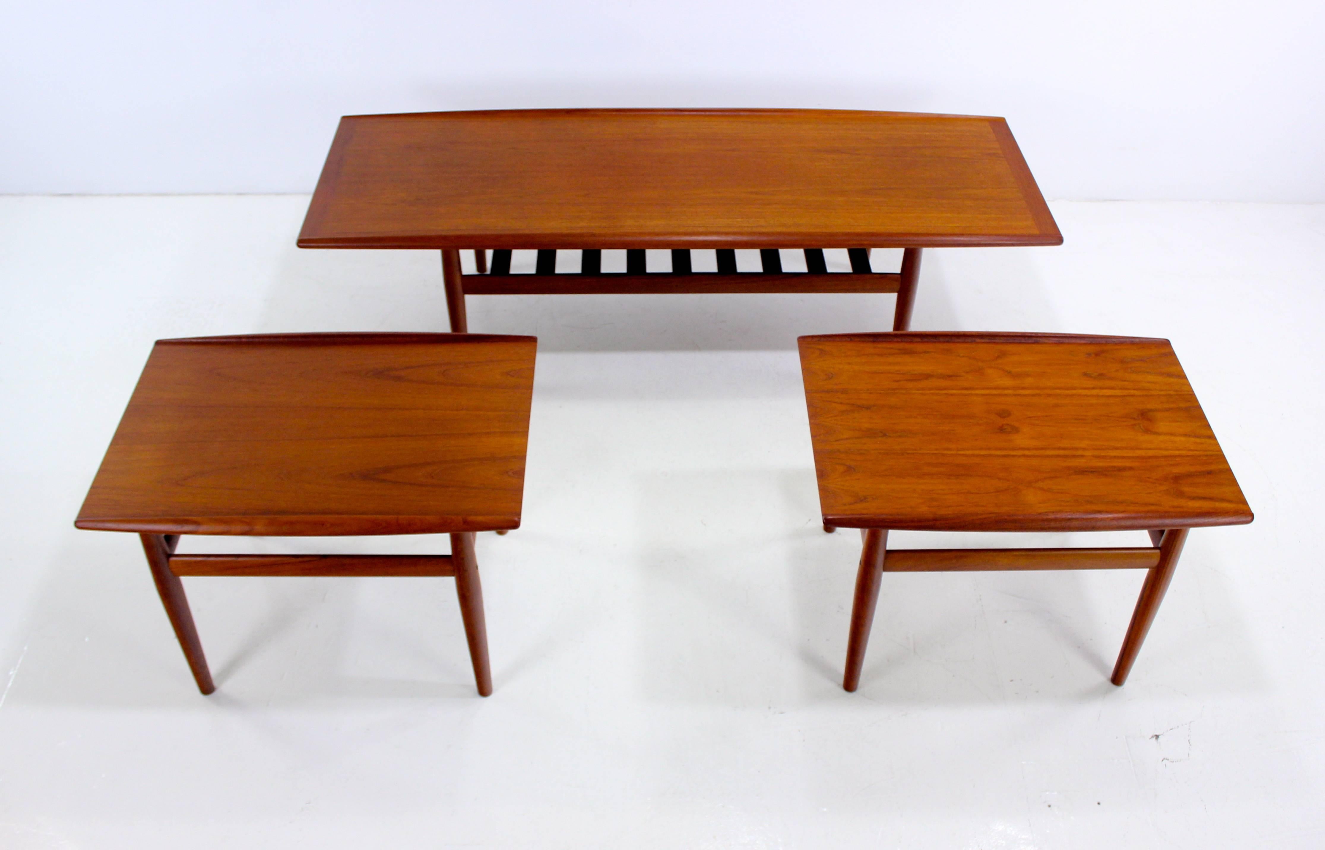 Three Danish modern tables designed by Grete Jalk.
Solid teak.
One coffee table with slated magazine shelf.
Two side tables measure 27.5" W x 19.75" D x 19" H.
Matchless quality and price.
Low freight and quick ship.
    