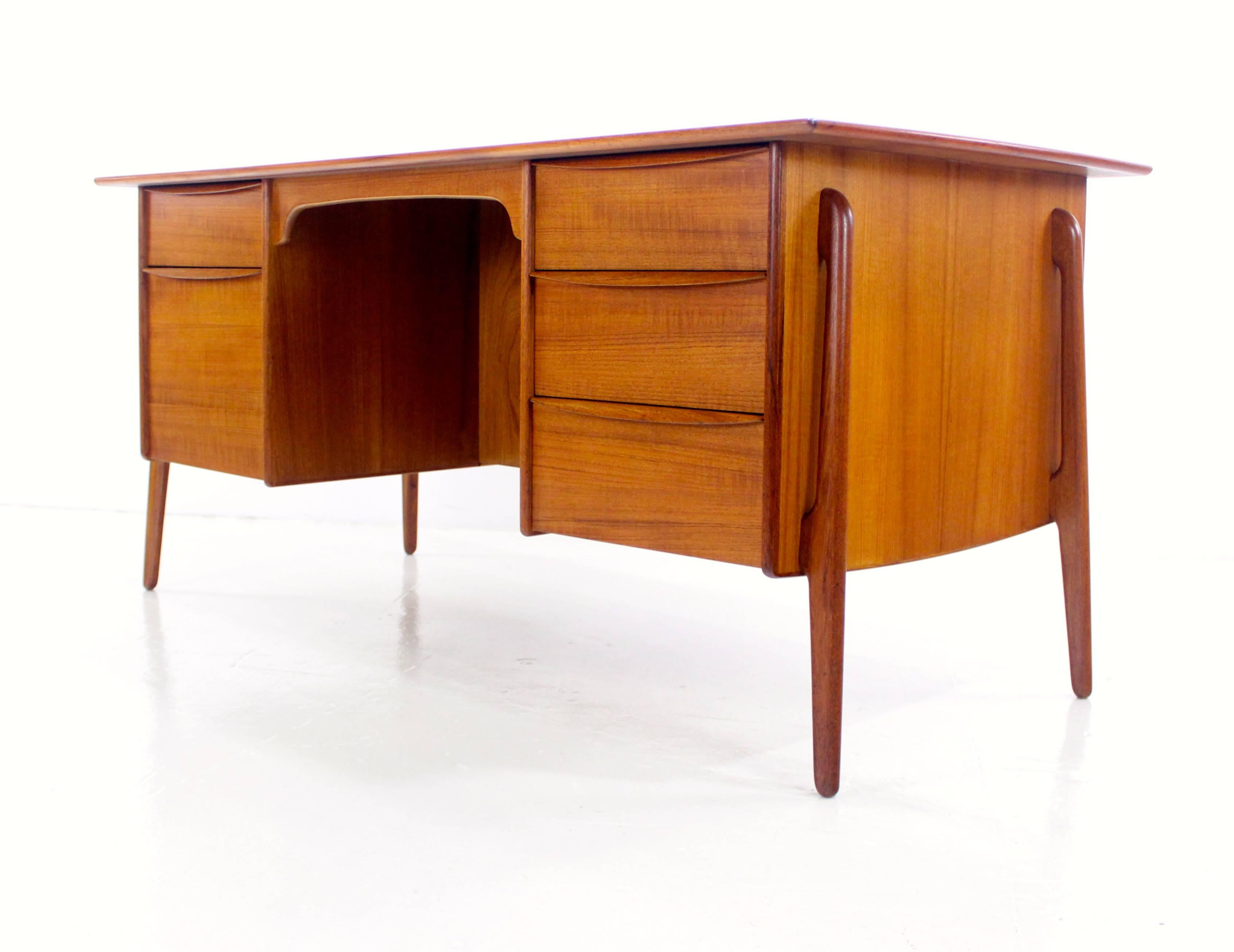Danish modern executive desk with superlative style and craftsmanship designed by Svend Madsen.
Richly grained teak.
Distinctive lines and unique curved leg configuration.
Three drawers on the right, two drawers on the left, bottom is a file