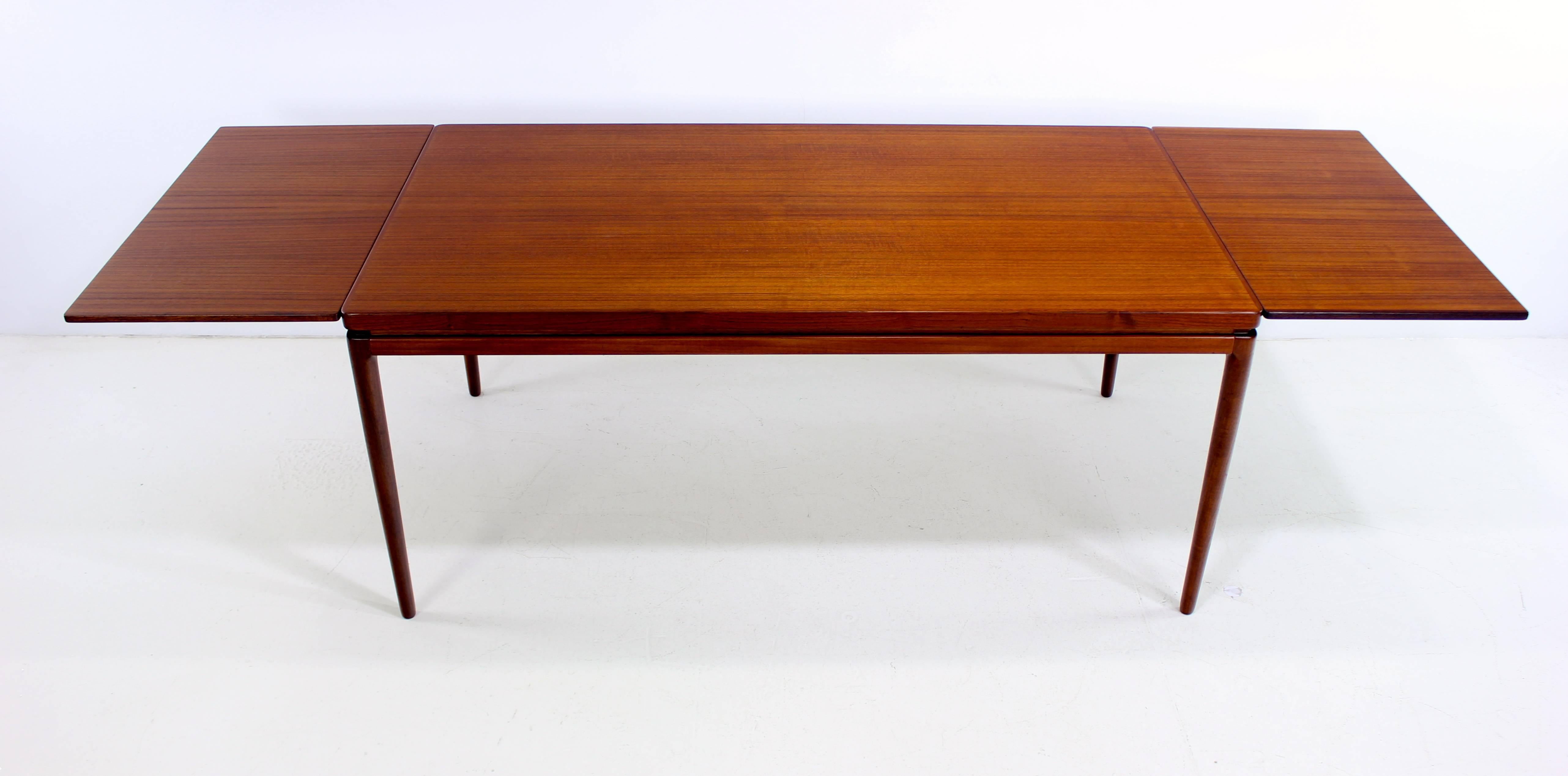 Danish modern dining table designed by Johannes Andersen.
Draw leaves pull-out from each end providing a full extension of 104.5