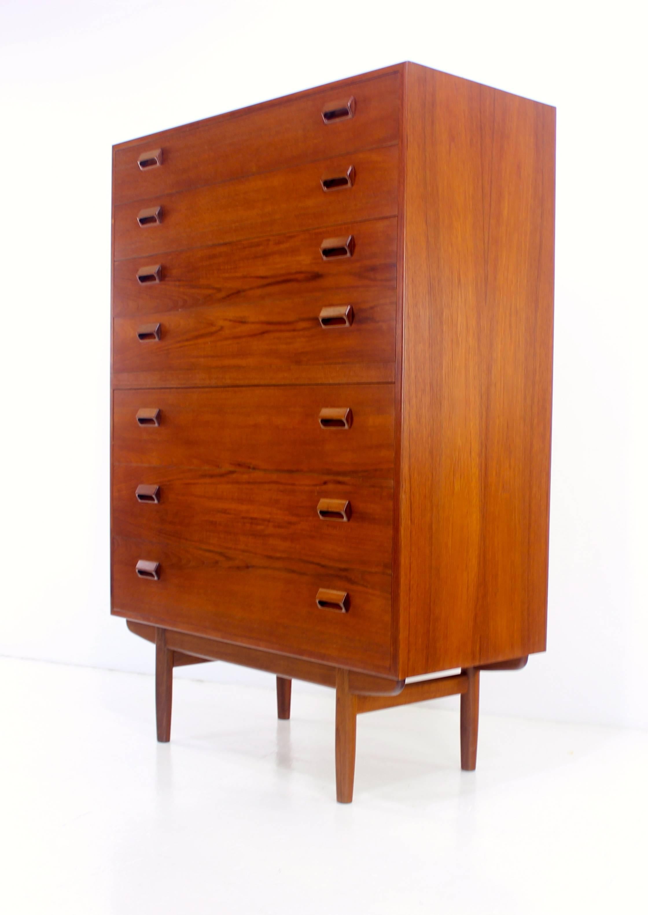 Danish modern highboy dresser designed by Børge Mogensen.
Richly grained teak.
Beautifully crafted base supports seven spacious drawers with signature Mogensen handles.
Professionally restored and refinished by LookModern.
Matchless quality and