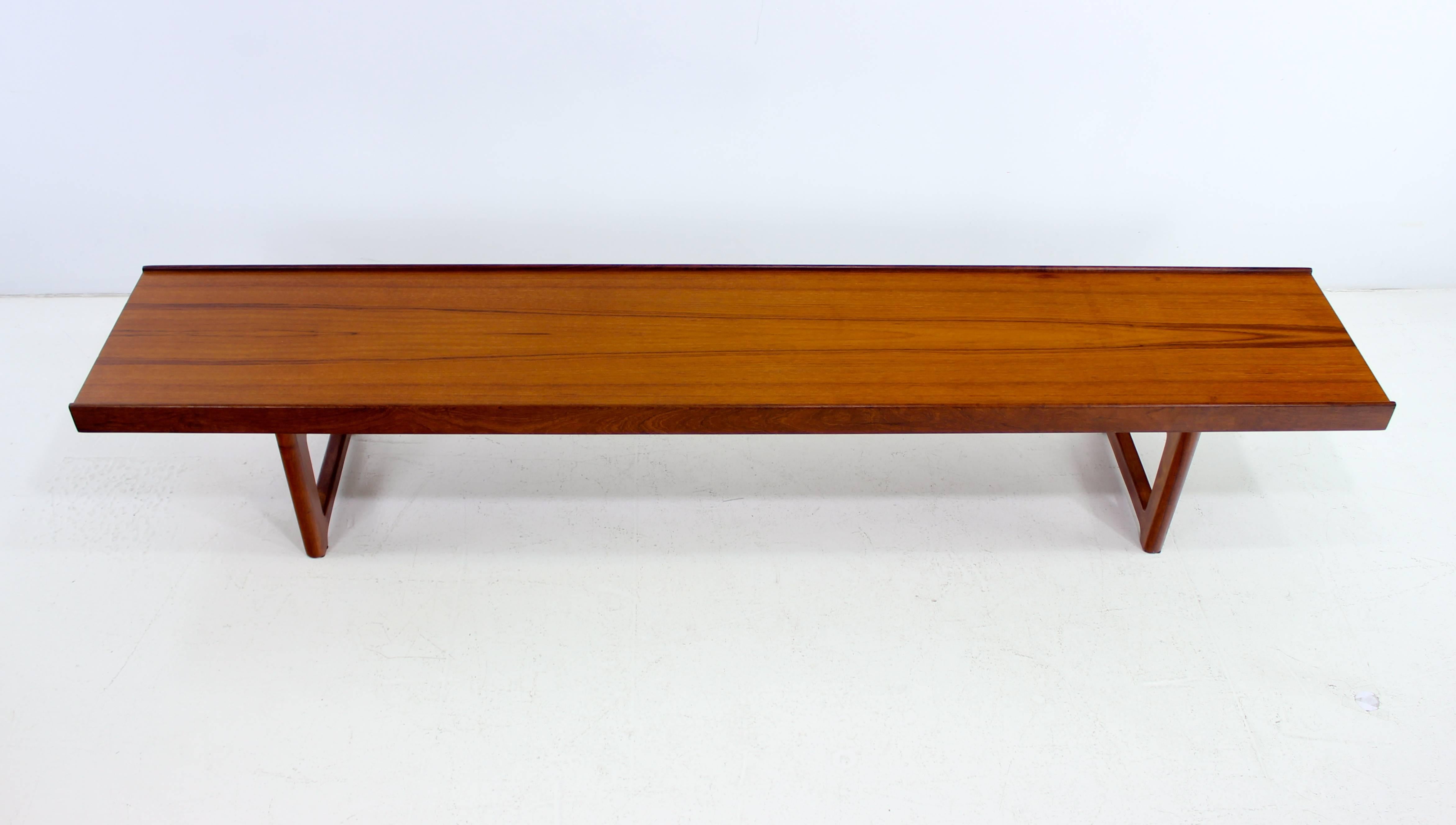 Scandinavian modern "Korbo" coffee table or bench designed by Torbjørn Afdal.
Mellemstrands Trevaro Industri A/S, maker.
Richly grained teak with lean minimalist lines.
Upturned edges accommodate seat cushions.
Professionally restored