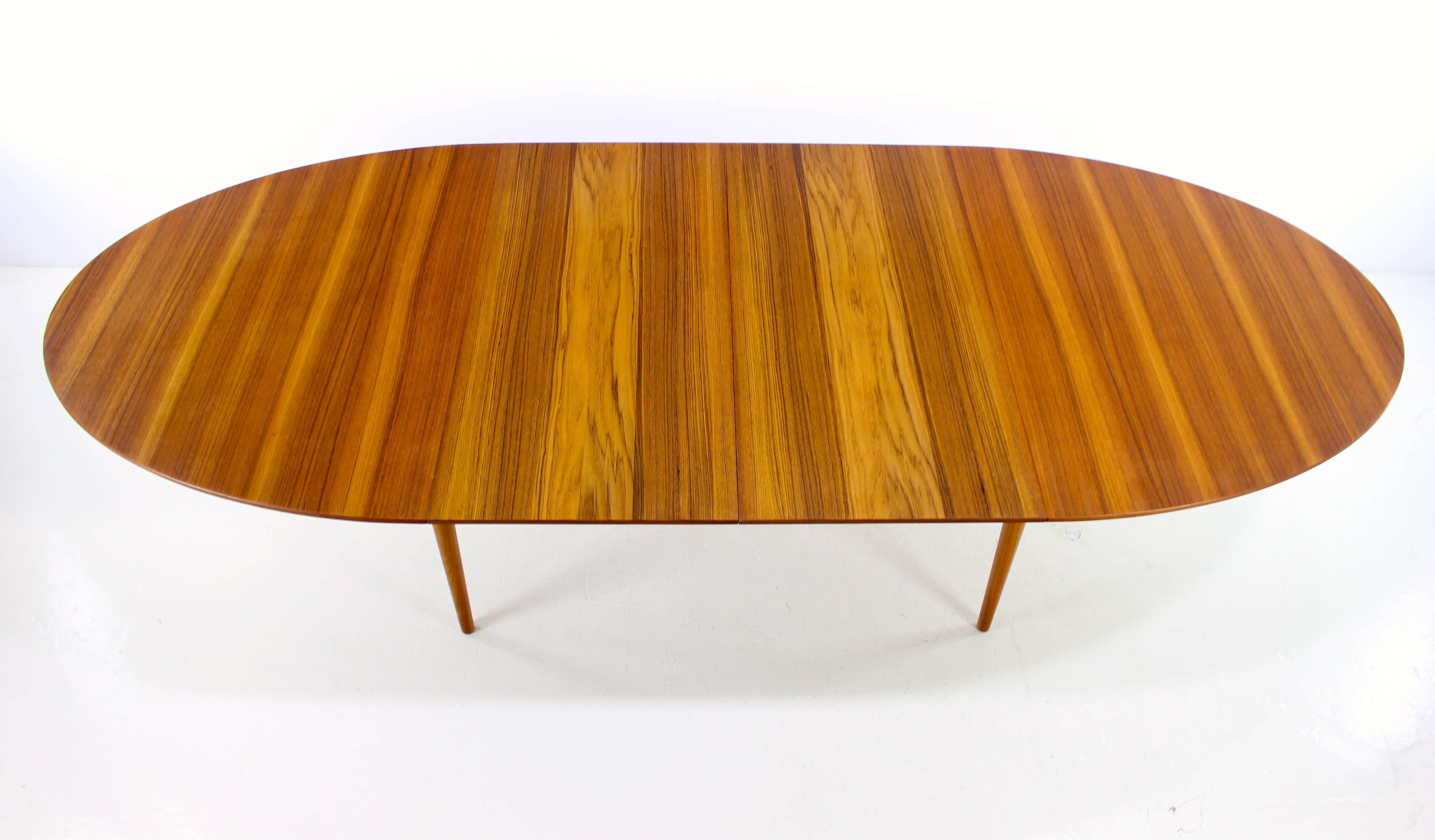 "Judas" dining table designed by Finn Juhl.
Niels Vodder, maker.
Richly grained teak with inset sculptural skirt and legs. Silver inlays in tabletop.
Two leaves, measuring 21.5" each provide full extension of