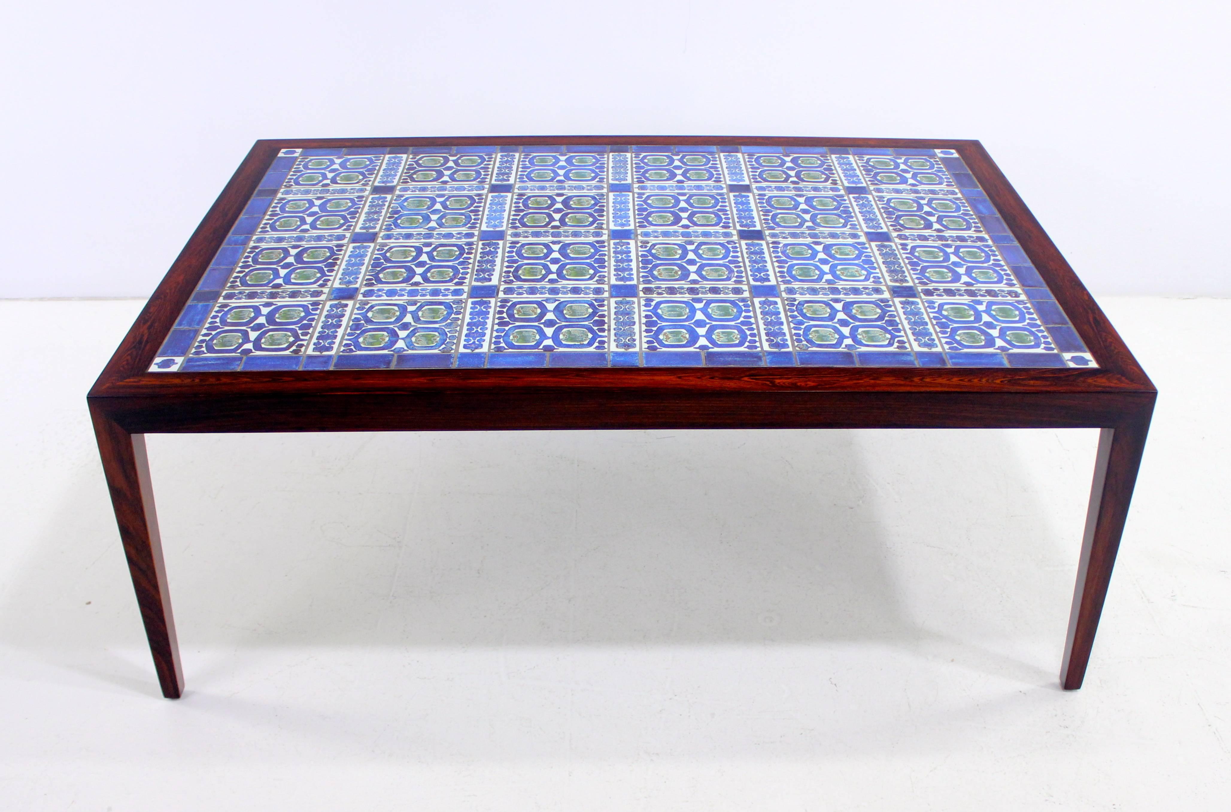 Danish modern coffee table designed by Severin Hansen Jr.
Hasley Mobelsndkeri, maker. 1972.
Rosewood frame with hand-painted, inlaid tiles by Grethe Hellan Hansen for Royal Copenhagen. Official Royal Copenhagen badge on table bottom.
Matching end