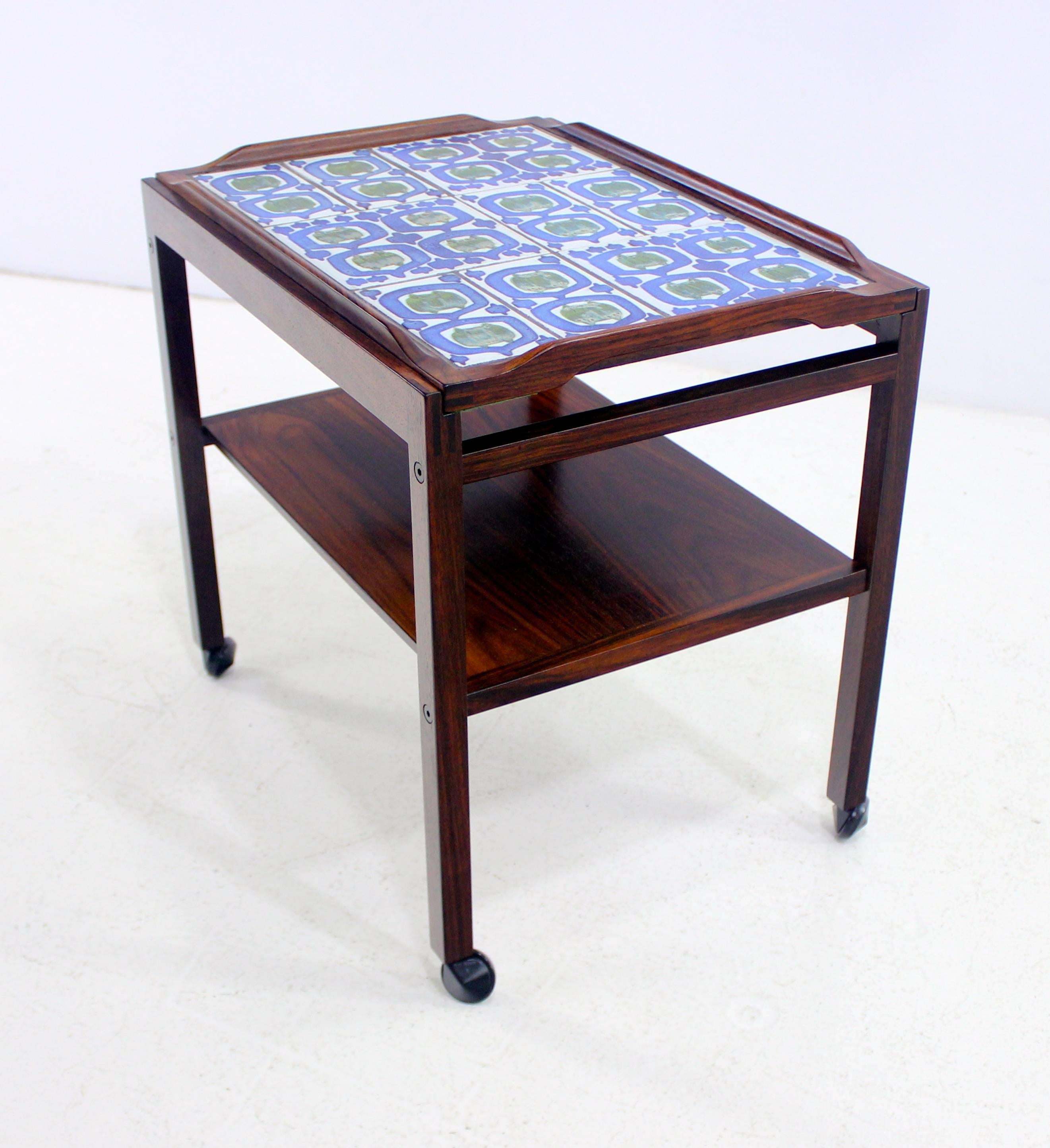 Danish Modern coffee tea cart designed by Severin Hansen Jr.
Haslev Mobelsndkeri, maker, 1973.
Rosewood frame with inlaid tile hand-painted by Grethe Helland Hansen for Royal Copenhagen.
Matching end table and coffee table listed
