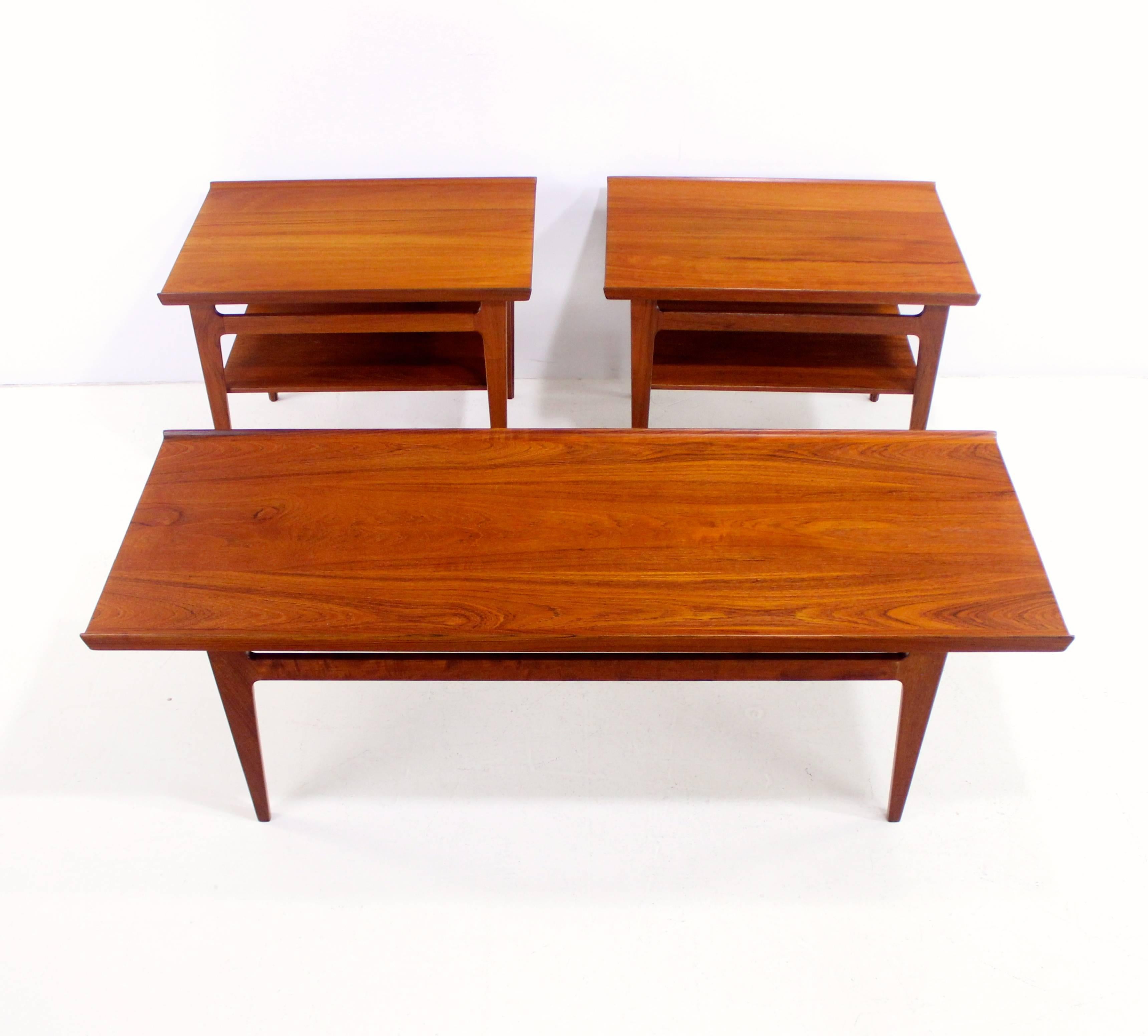 Danish modern three-piece table set designed by Finn Juhl.
France & Son, maker.
One solid teak coffee table with signature Juhl raised edges.
Two solid teak end tables with signature Juhl raised edges and lower shelf.
End tables measure: