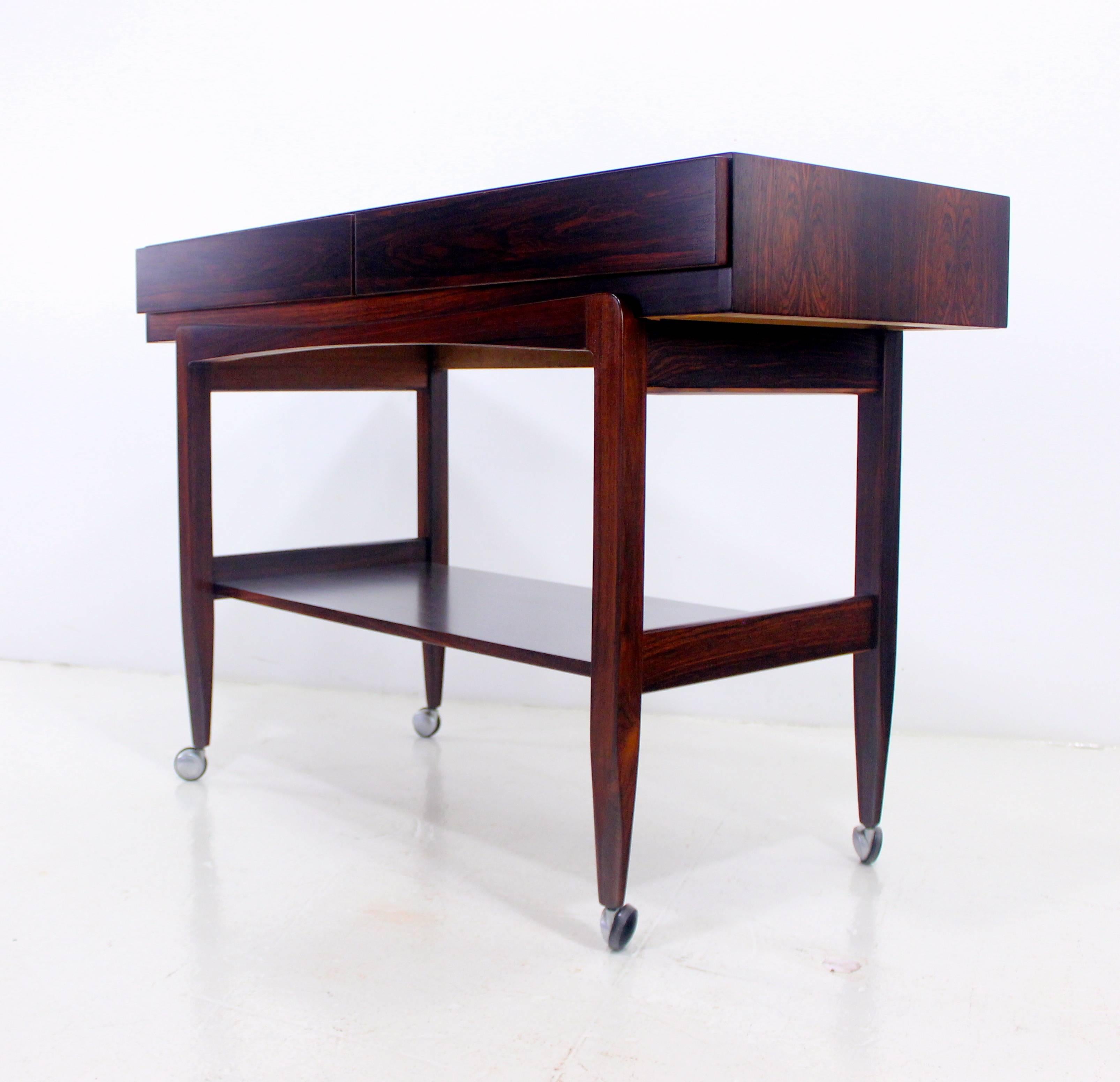 Danish modern console or server designed by Ib Kofod Larsen.
Incredibly rare and illusive.
Rich rosewood.
Floating top with two drawers. Elegantly styled base on wheels.
Finished on the back for 360° use.
Professionally restored and refinished