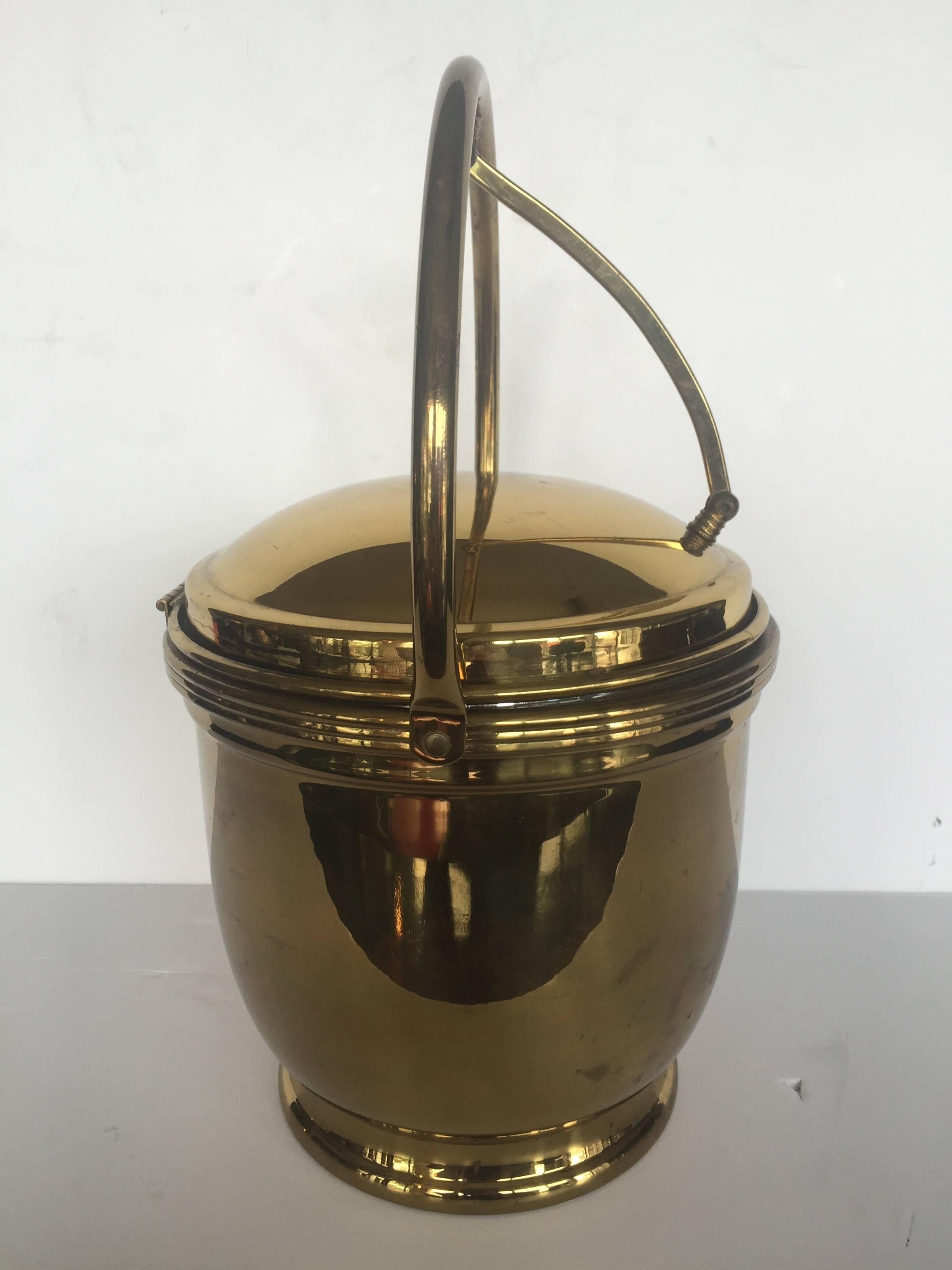 Stunning brass ice bucket with attached cantilever handle and lined with mercury glass. 