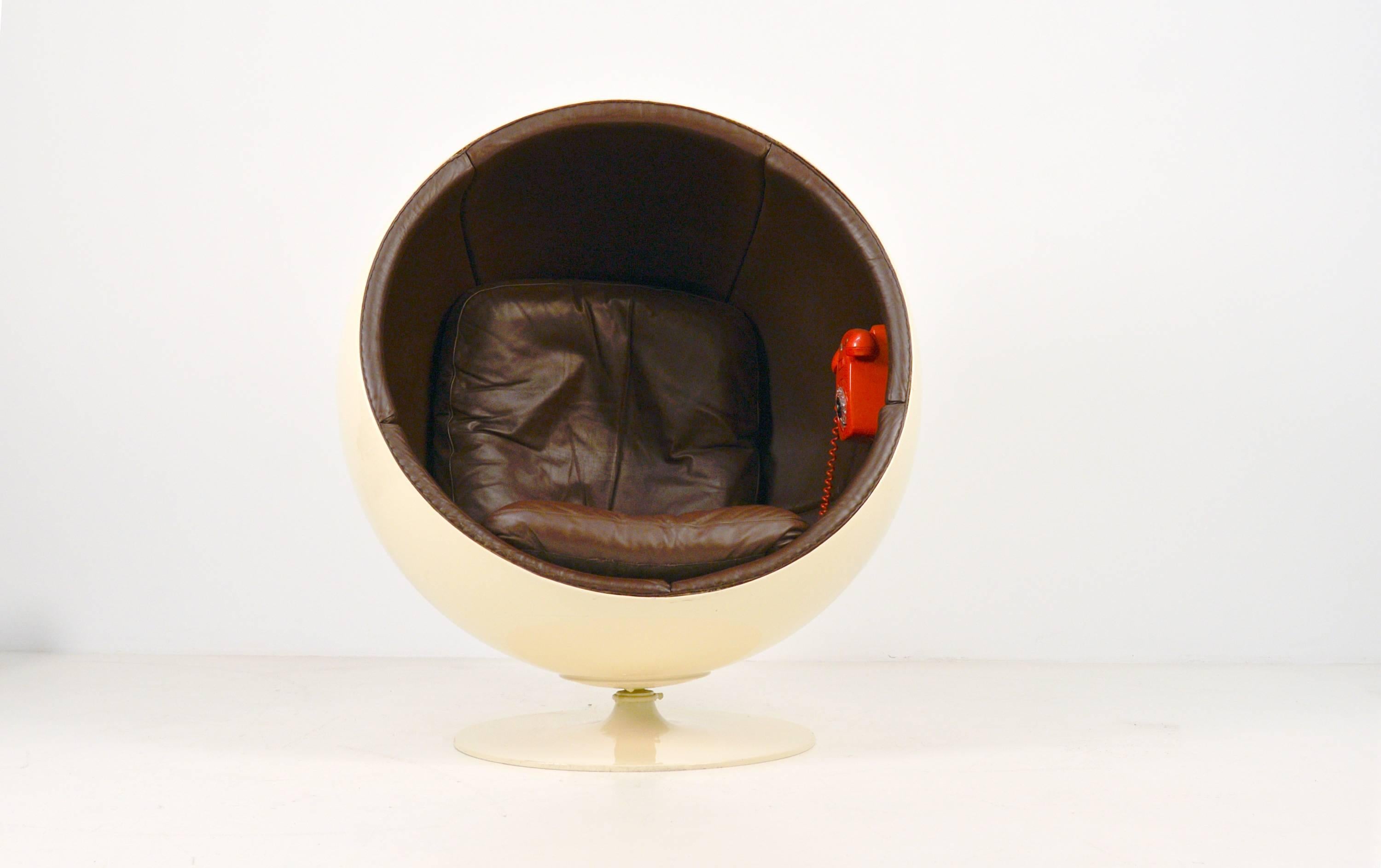 Rare 1st edition ball chair made by Asko, Finland and designed by Eero Aarnio in 1963. Nowadays they are made by Adelta. Beige shell and brown leather upholstery. This one has the rare red Ericsson phone inside of which there were only a few