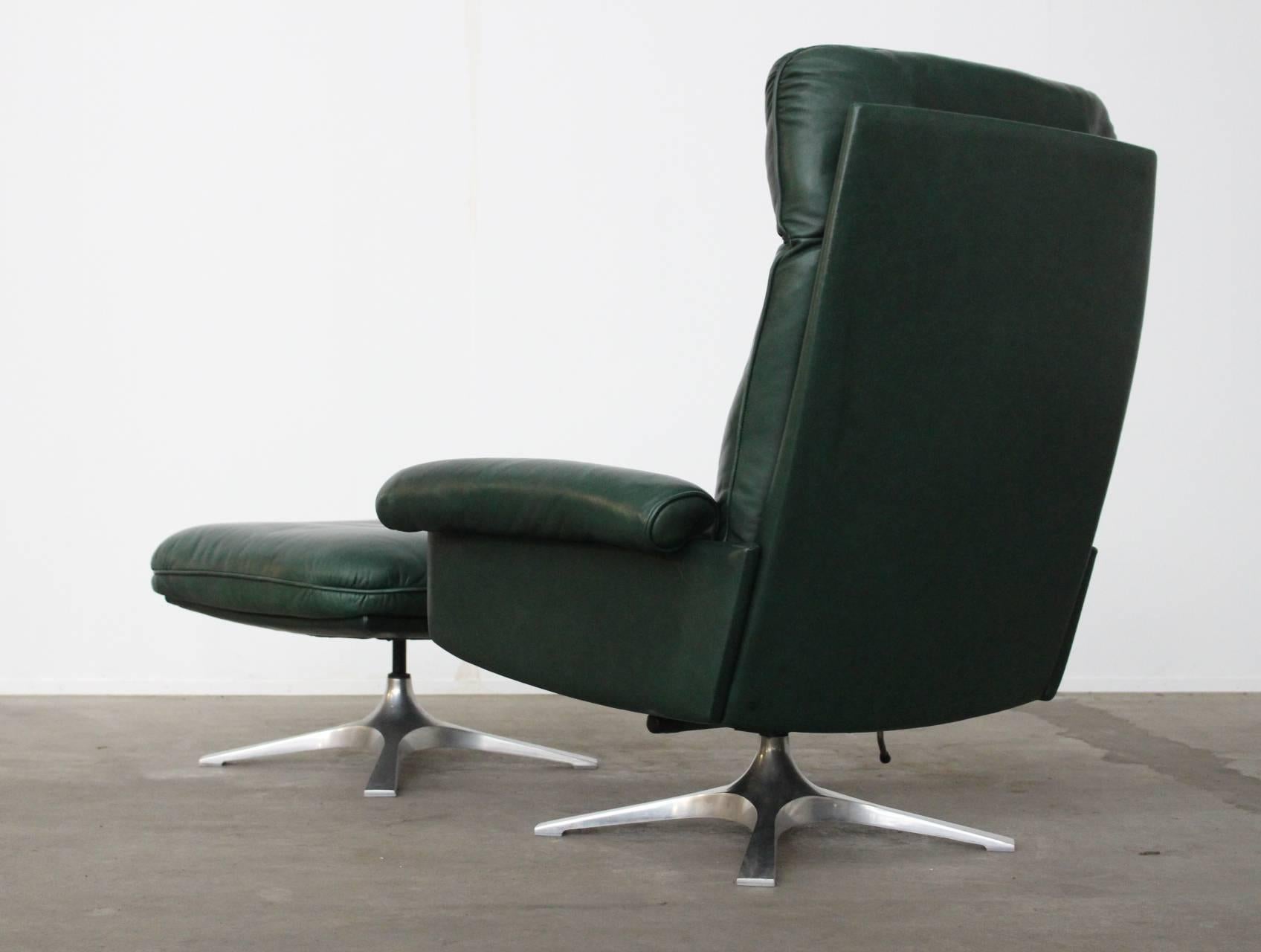 Beautiful highest quality green leather upholstered lounge chair of model DS31 by De Sede, Switzerland with its matching swiveling hocker/ footstool.
This is the model with the beautiful polished aluminum four-leg tulip base with stabilizers at the