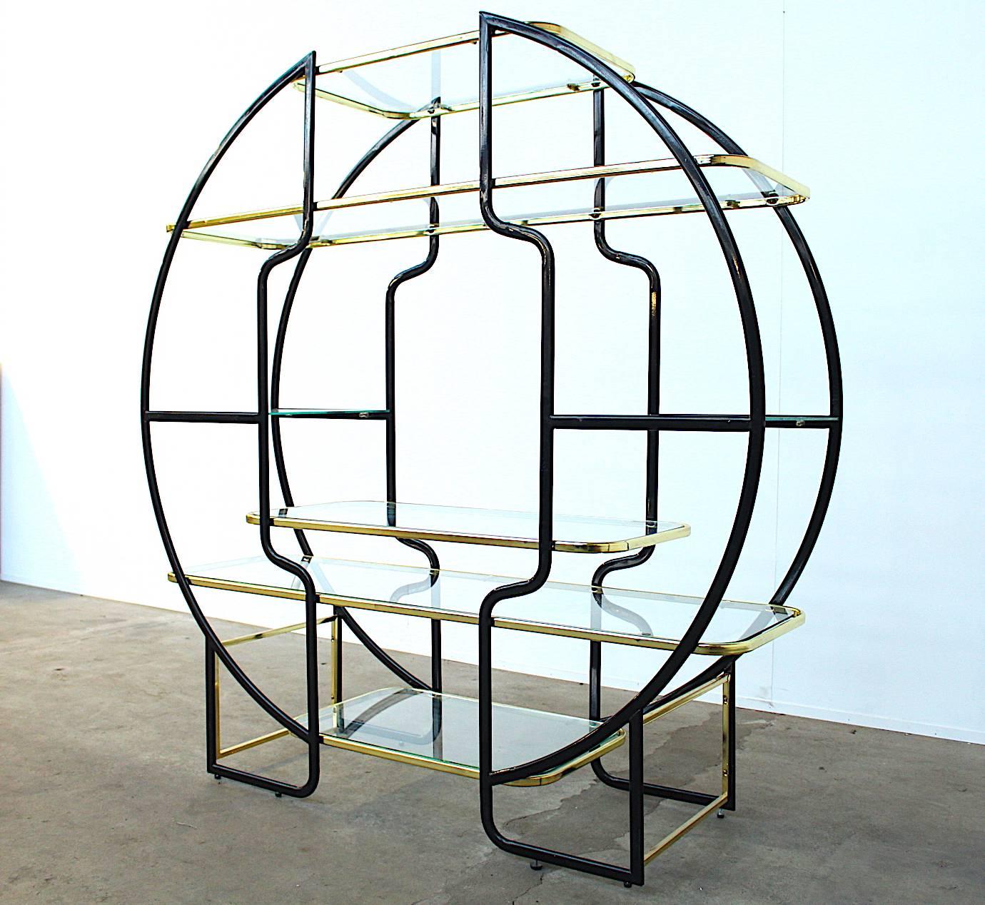 Beautiful Maison Jansen style round étagère or vitrine with seven tempered glass shelves in a frame of brass and black lacquered metal. Highly decorative and imposingly large piece; a very impressive eye catcher in any interior. The piece is fitted