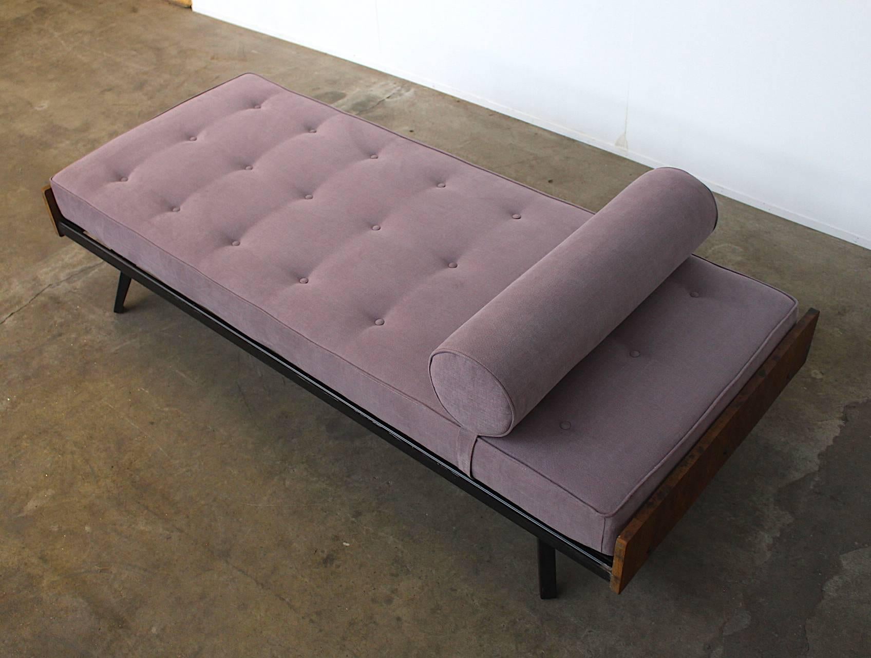 French daybed from the 1950s in the style of Jean Prouvé. This daybed looks very similar to the SCAL daybed from Atelier Prouvé. It has a black enamelled steel frame with solid wood ends. The mattress and cushion are newly upholstered with the best