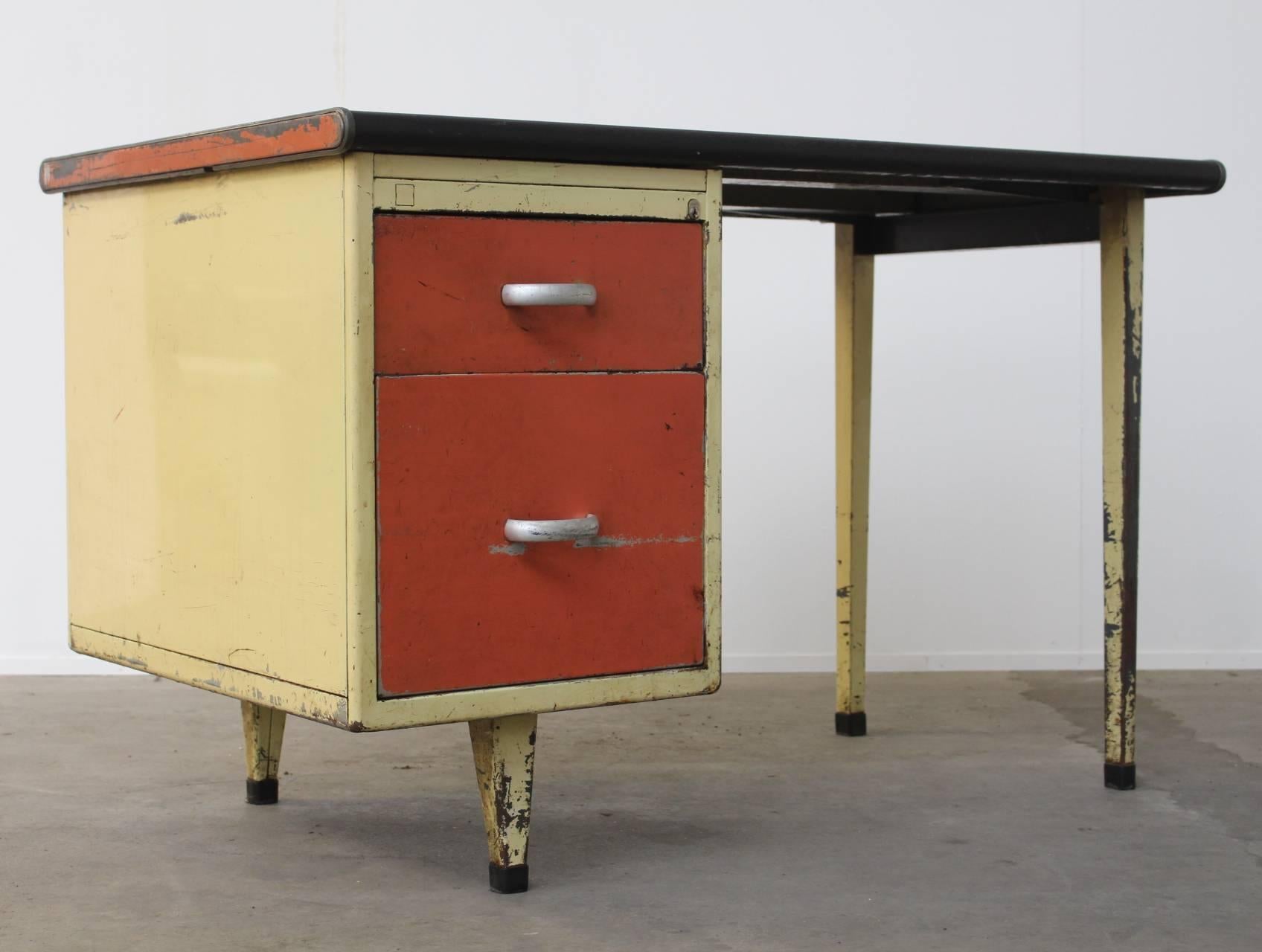 Beautifully patinated industrial desk or writing table in the style of Jean Prouvé. The colors yellow and red exactly match those of the famous President Desk by Prouvé. Beautiful eye catcher in any interior.