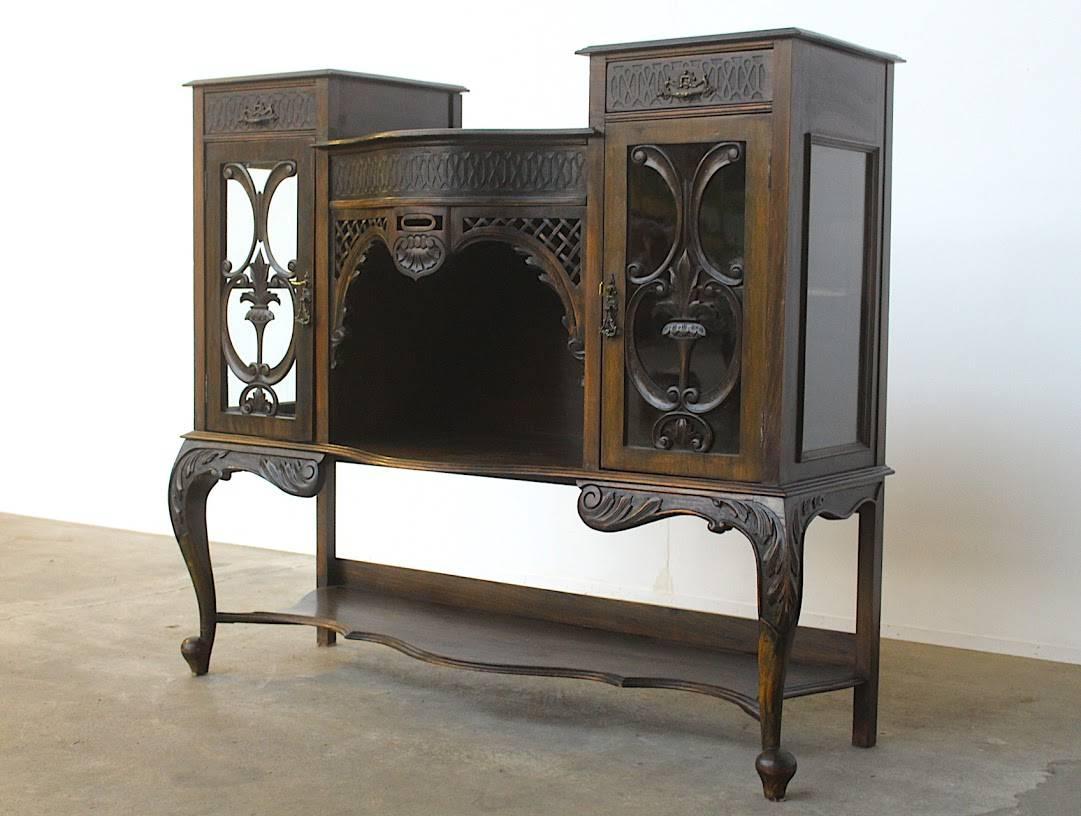 Wonderfully crafted and very elegant cabinet with two glass vitrine compartments, on the inside upholstered with a gold coloured velvet. There are two (cutlery) drawers on top of each vitrine and an open middle compartment. The plentiful carvings