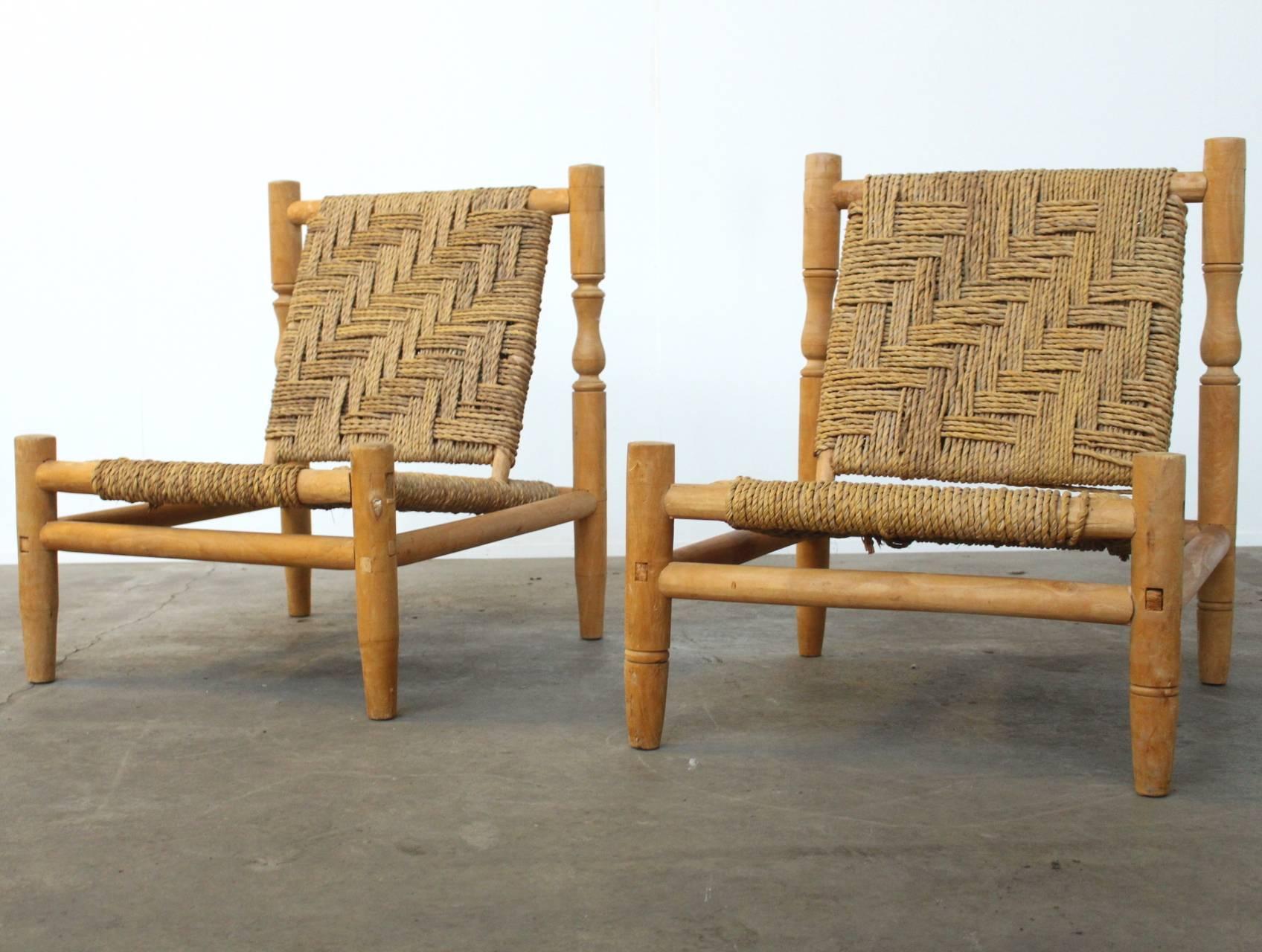 Beautiful pair of two French lounge chairs or easy chairs in the style of Charlotte Perriand. The frame of the chairs is made of ashwood and the seat and backrest are made of woven sisal. The chairs have a wonderfully crafted structure and are