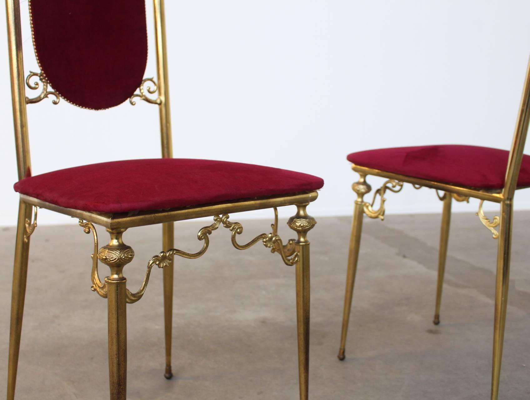 Beautiful side chairs upholstered in red velvet with a beautifully crafted brass frame. These chairs are new old stock, they have never been used previously. The former owner still left the original plastic vacuum cover over the seats, which we