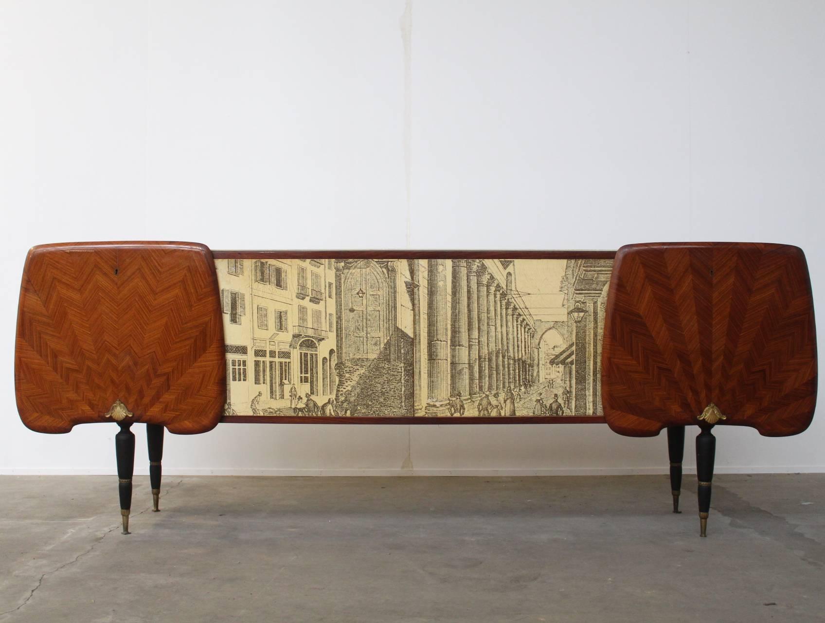 Stunning and beautifully carved large sideboard in the style of Gio Ponti with a beautiful lacquered print in the style Piero Fornasetti. The top of the piece is finished with abeautiful opaline white Murano glass cover. Possibly made by Dassi,