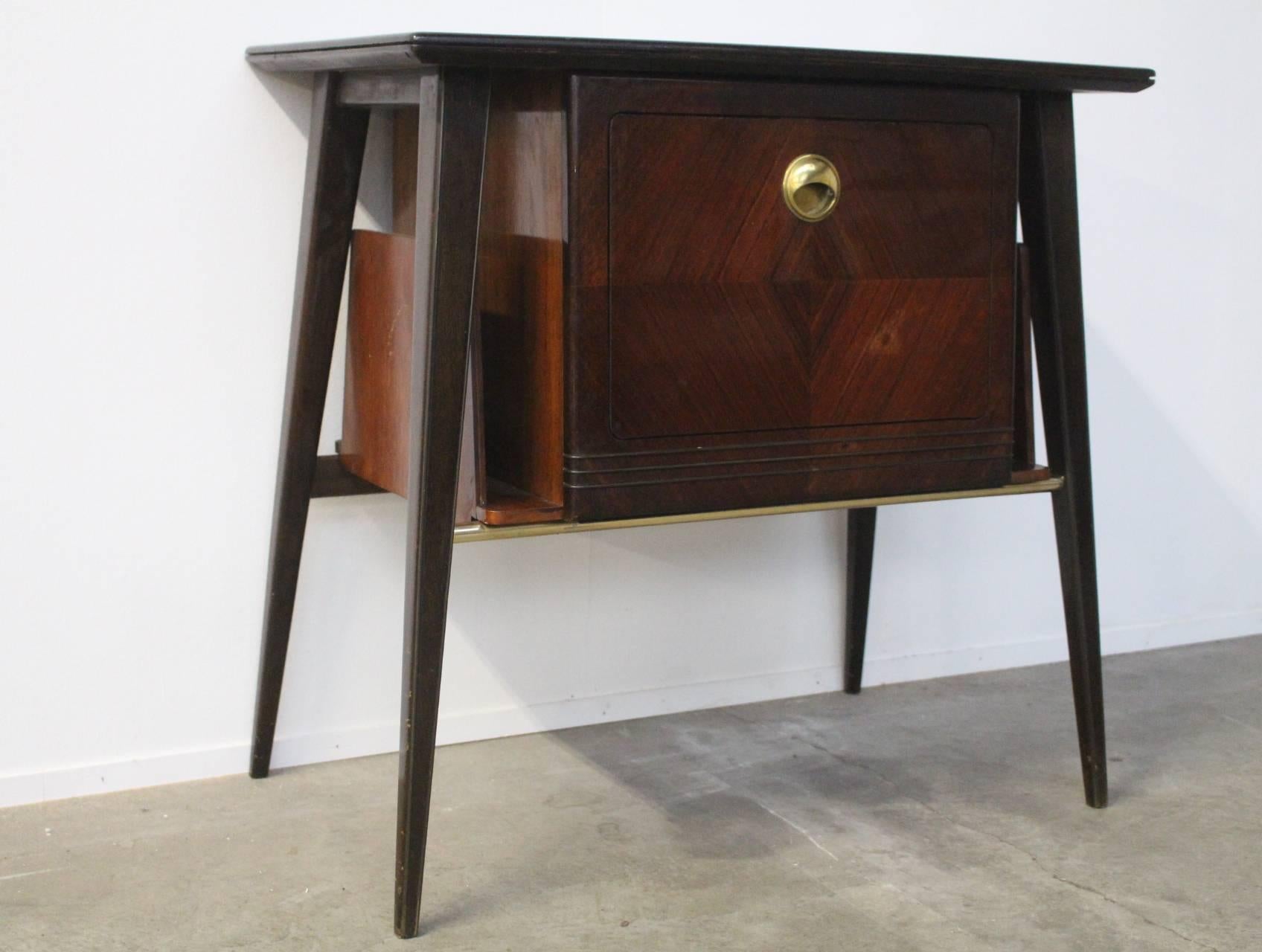 Beautiful Italian side table made of tropical wood with magazine racks at both sides.