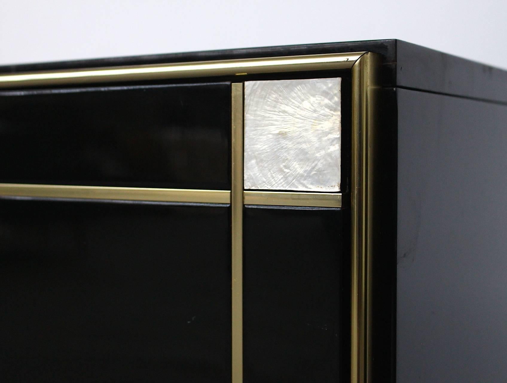 Set of two very chic Hollywood Regency black high gloss piano lacquer cabinets with amazing mother-of-pearl inlay around the doors and sleek brass door handles. Designed by Willy Rizzo for the prestigious luxury retailer Mario Sabot in Italy. Both