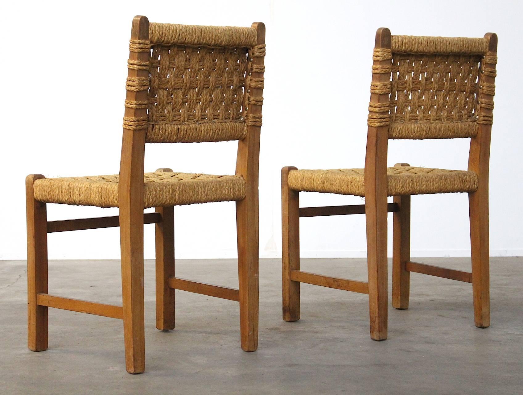 A stunning pair of oakwood and rope/ sisal side chairs by the designer couple Adrien Audoux and Frida Minet; manufactured in the 1950s in Marseille, France. Beautiful minimalistic design with lots of similarities and suggestions to the work of