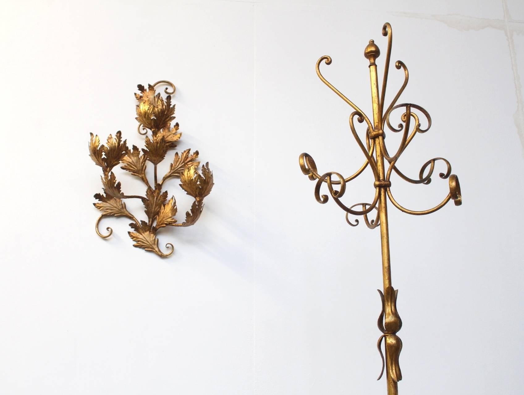 Beautiful eye-catching hall way set of a gold painted metal coat rack with three matching coat hangers, an umbrella basket and a decorative wall object with branches and leafs. All in the style of Adnet and Royere. Measurements below is the coat